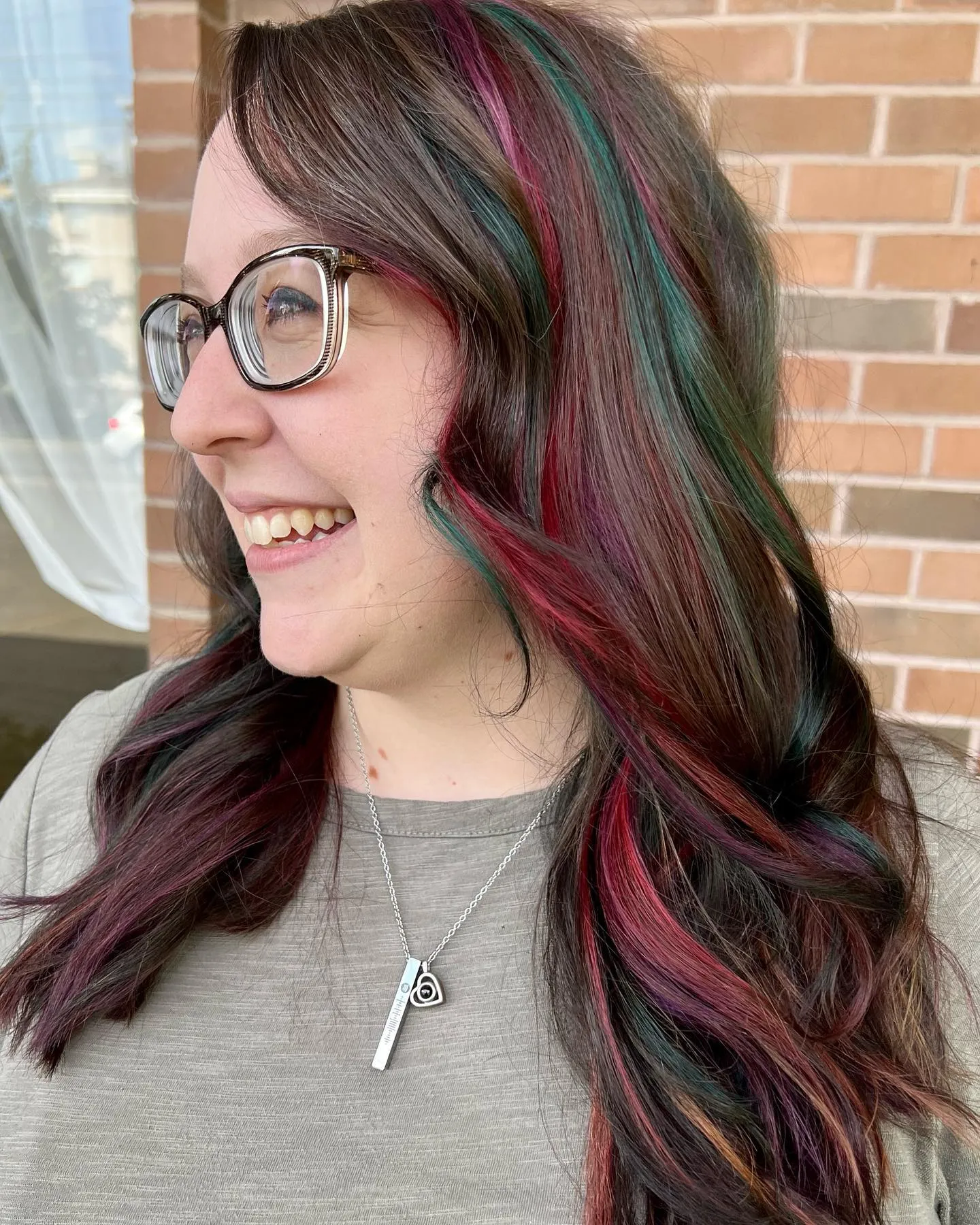 Long brunette waves with chunky magenta and teal highlights