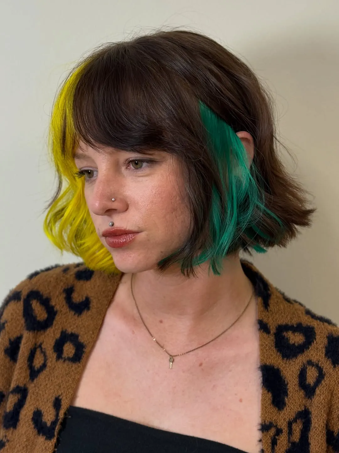 Short brown bob with yellow and teal face-framing colour panels
