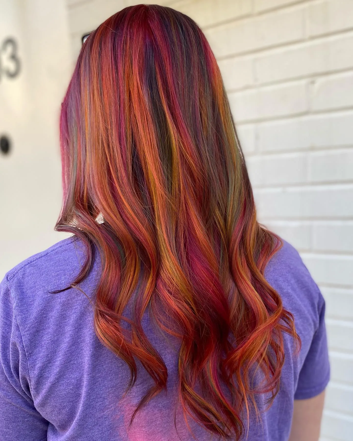 Long wavy hair with red, magenta and orange ribbon highlights