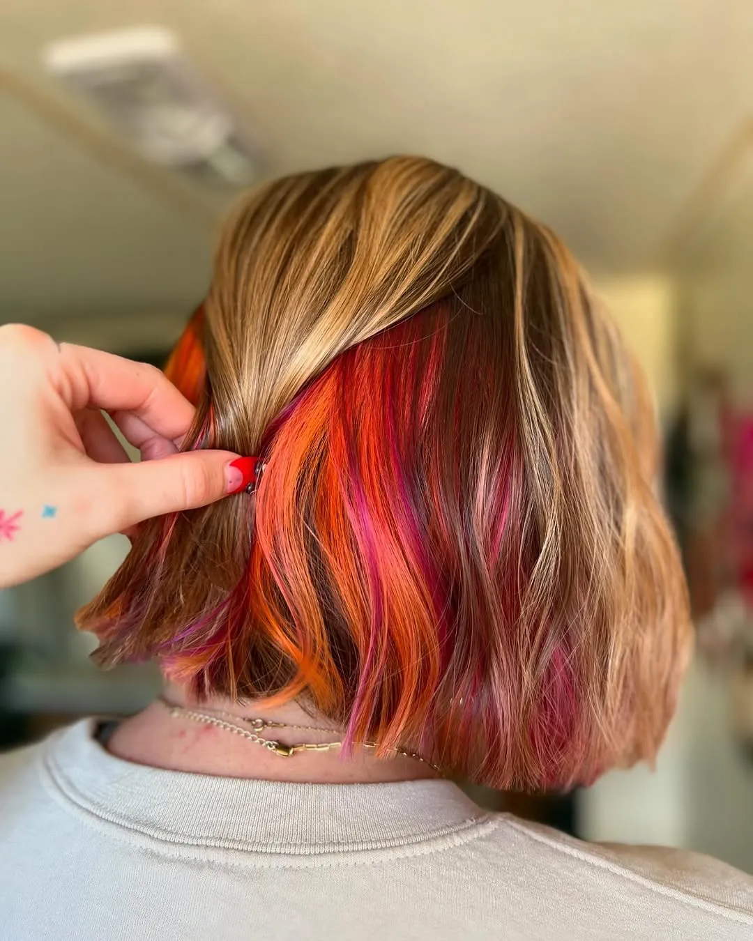 Blonde bob with hidden red, pink and orange colour underneath