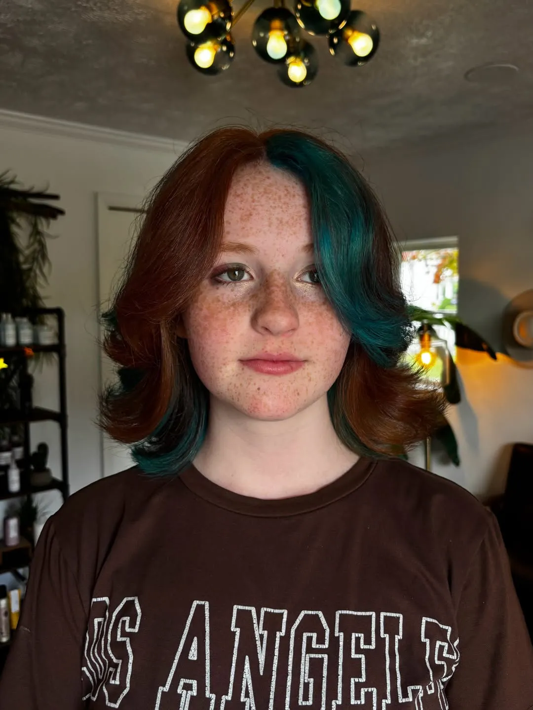 Short flipped bob split between warm brown and deep teal