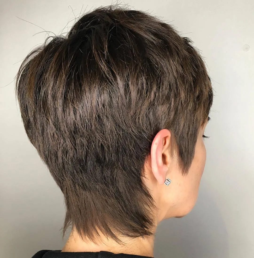 Stacked feathered pixie with a rounded crown and tapered wispy nape