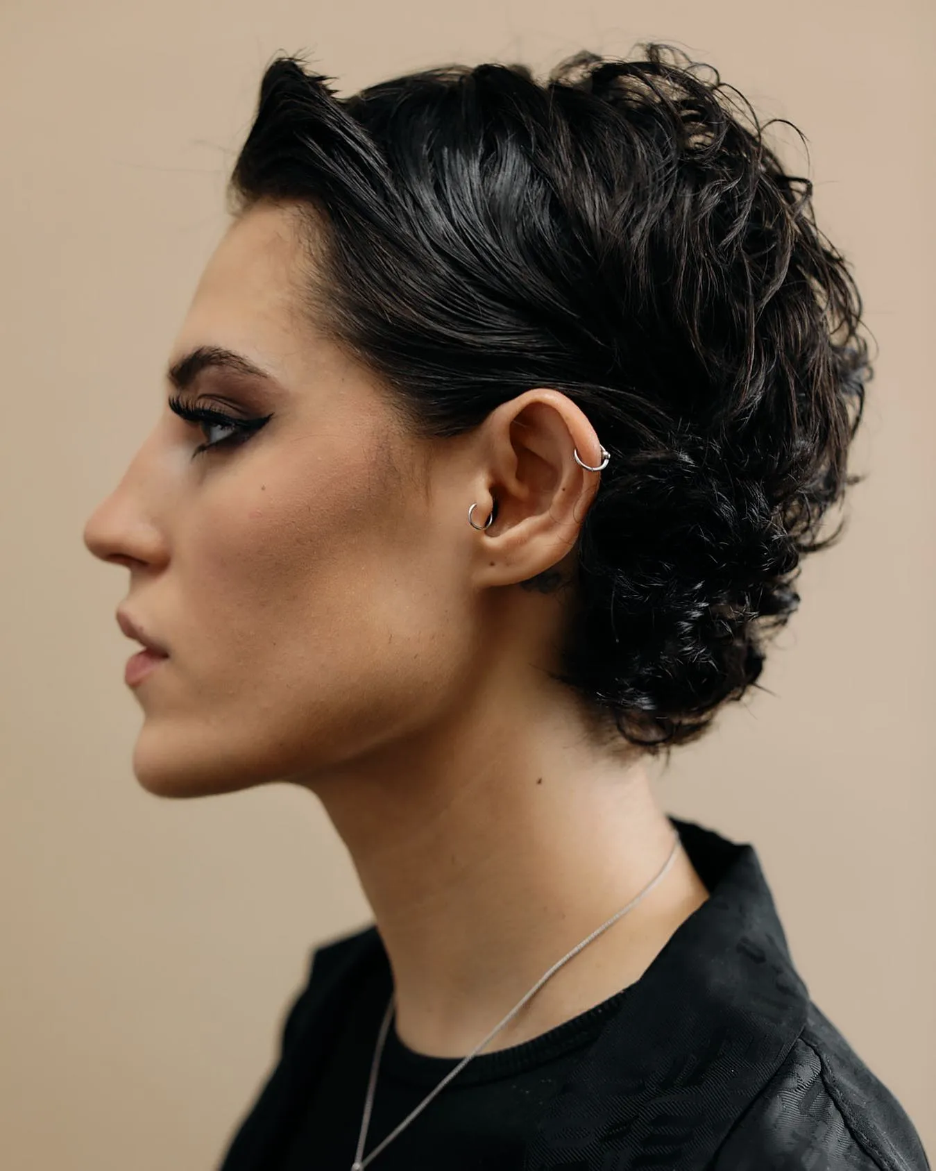 Curly feathered pixie with swept-back sides and defined curls