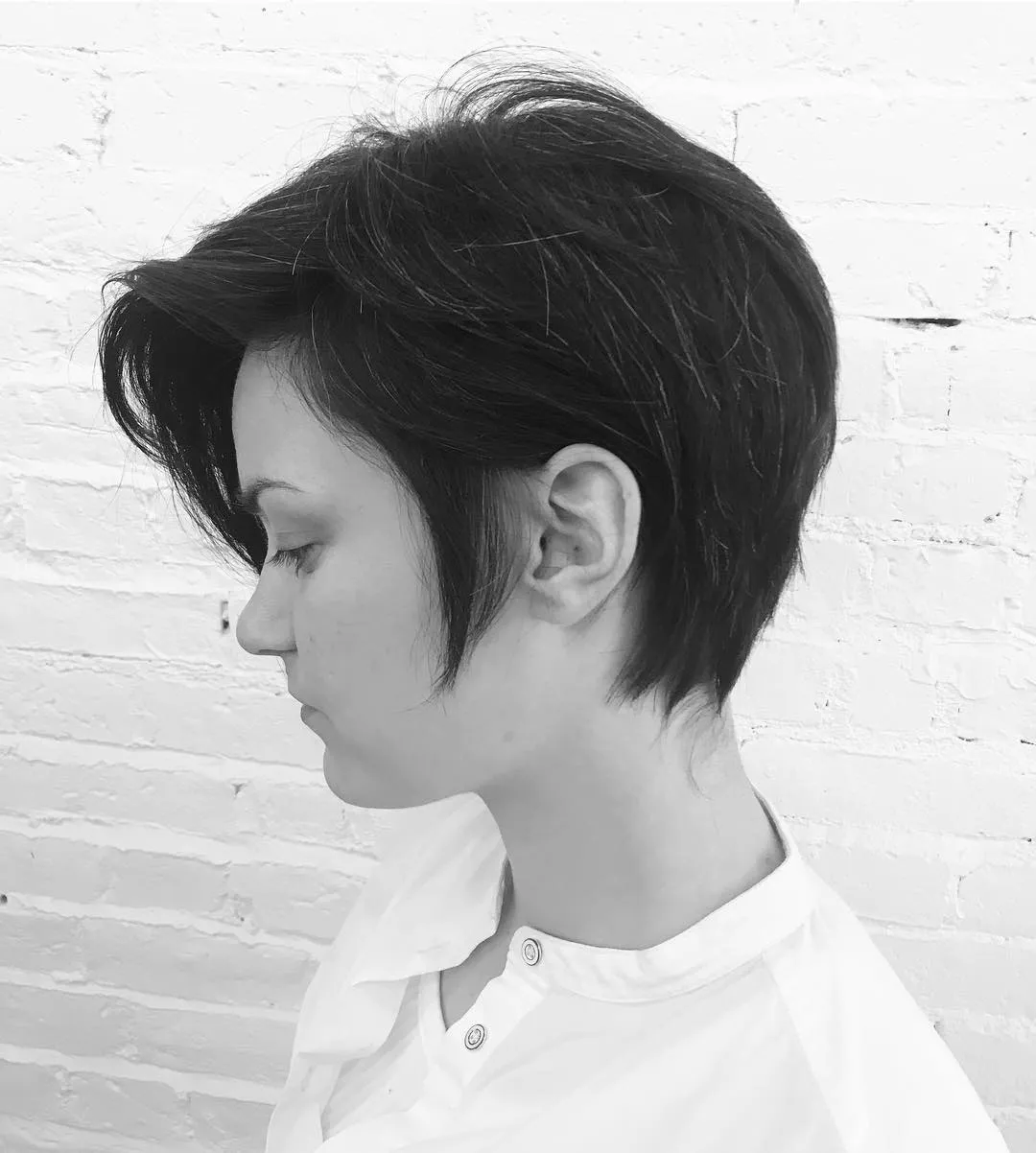 Asymmetrical pixie with sweeping top layers and a tapered nape