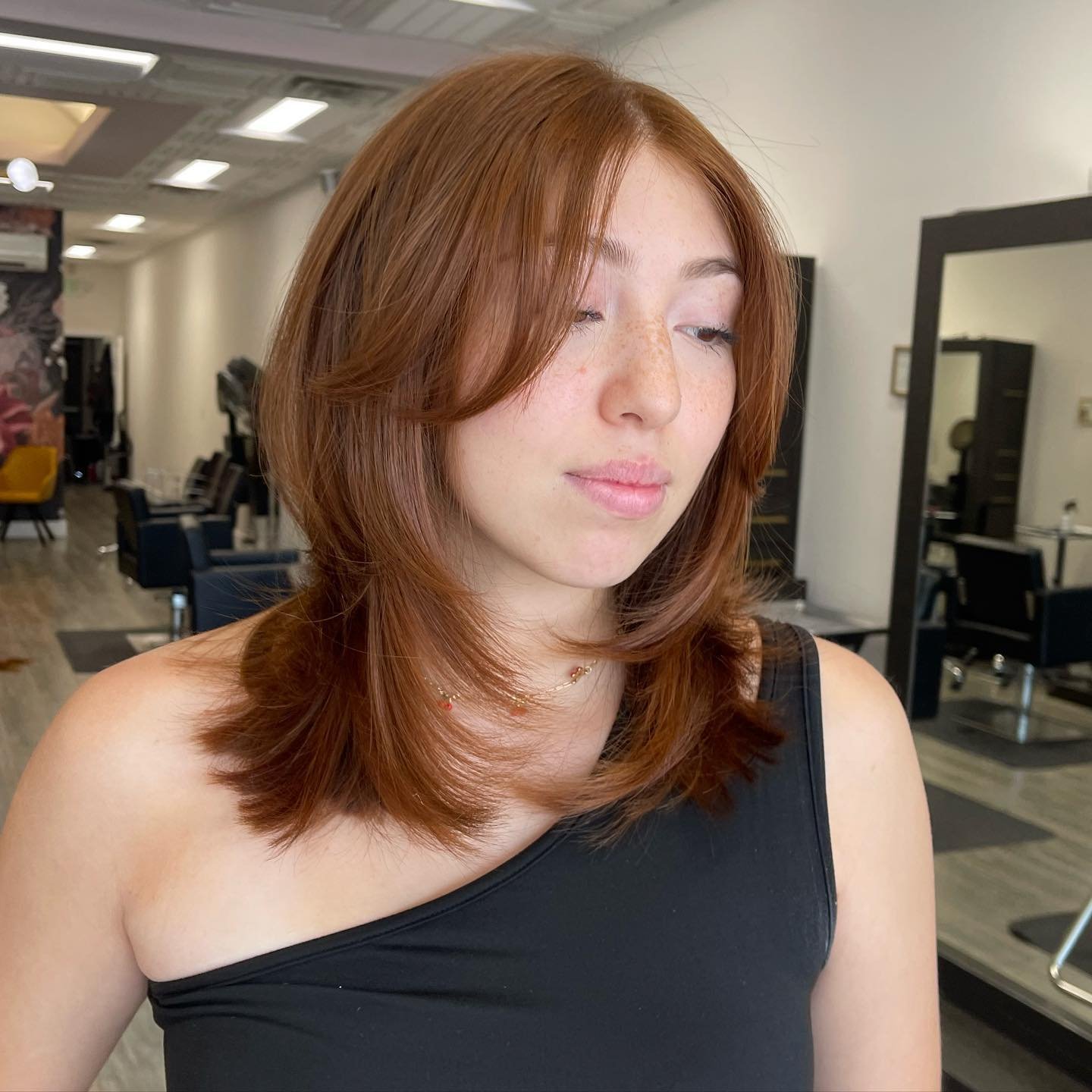shoulder-length layered haircut with a soft curtain fringe