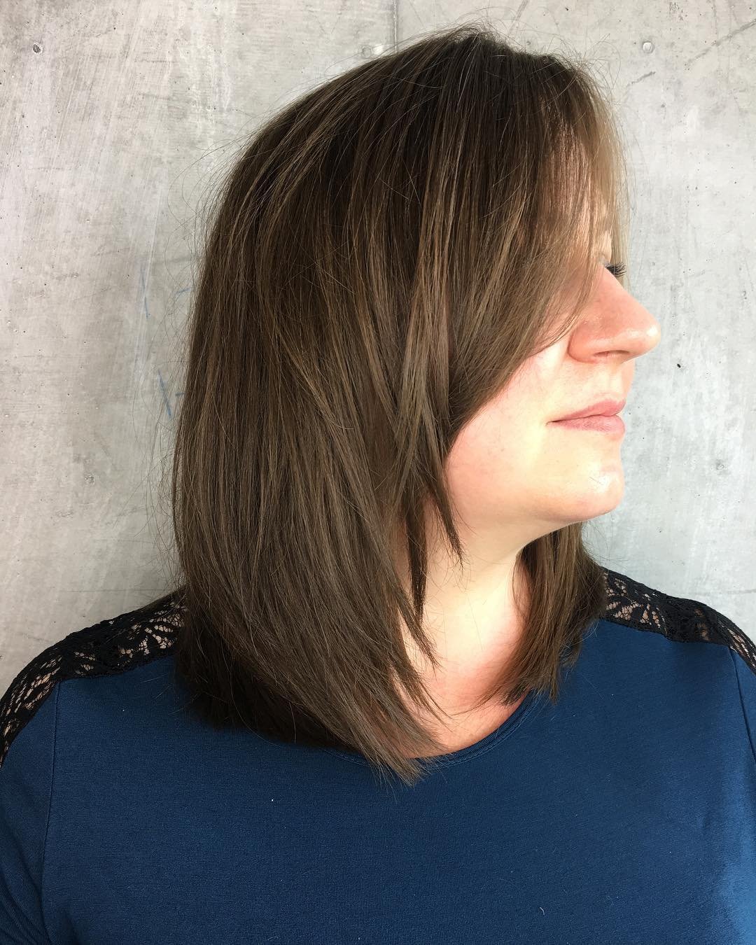 medium layered haircut with a long side-swept fringe