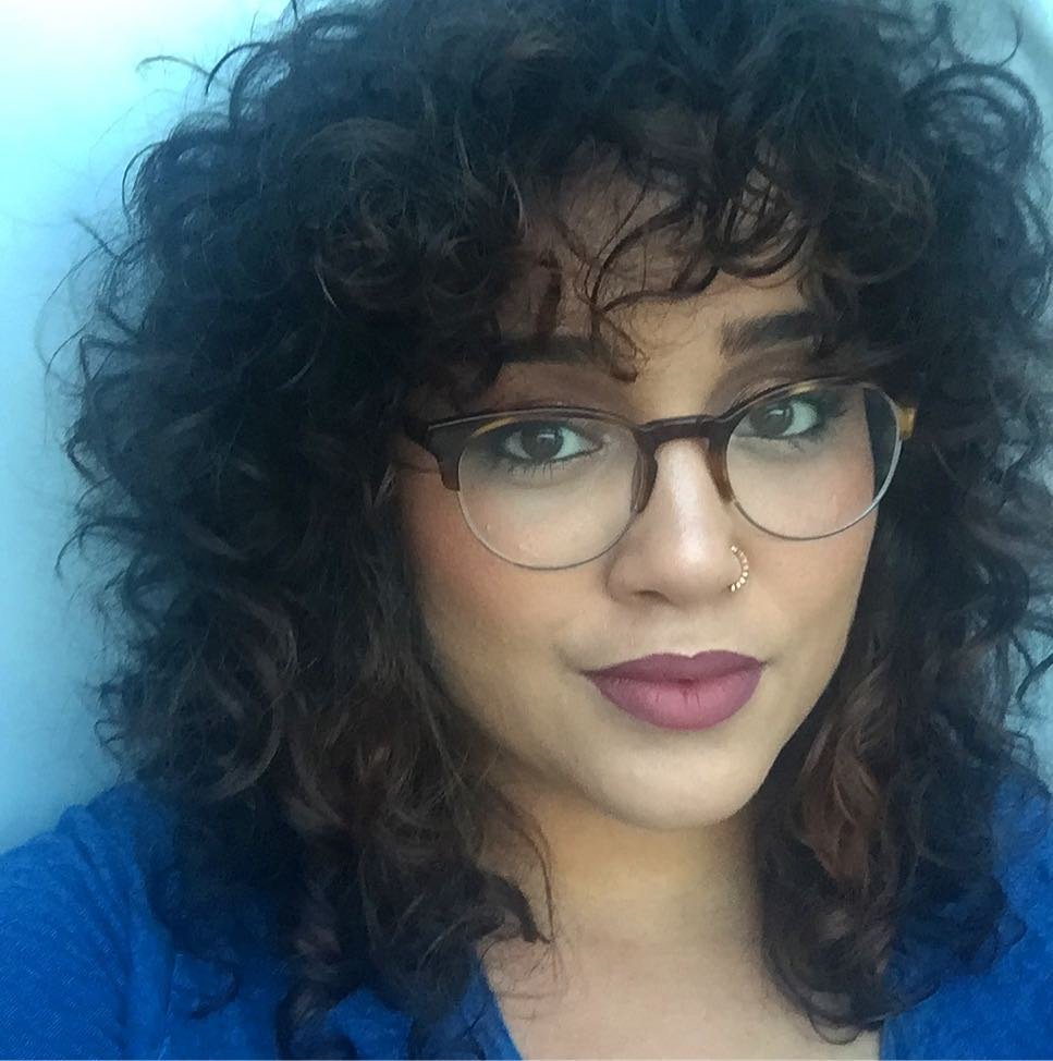 voluminous curly shag haircut with a full curly fringe