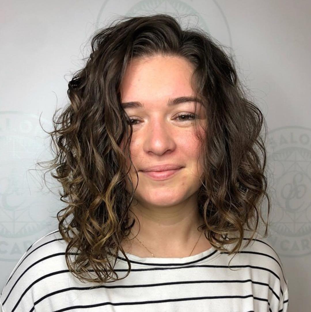 defined shoulder-length curly haircut with a centre part