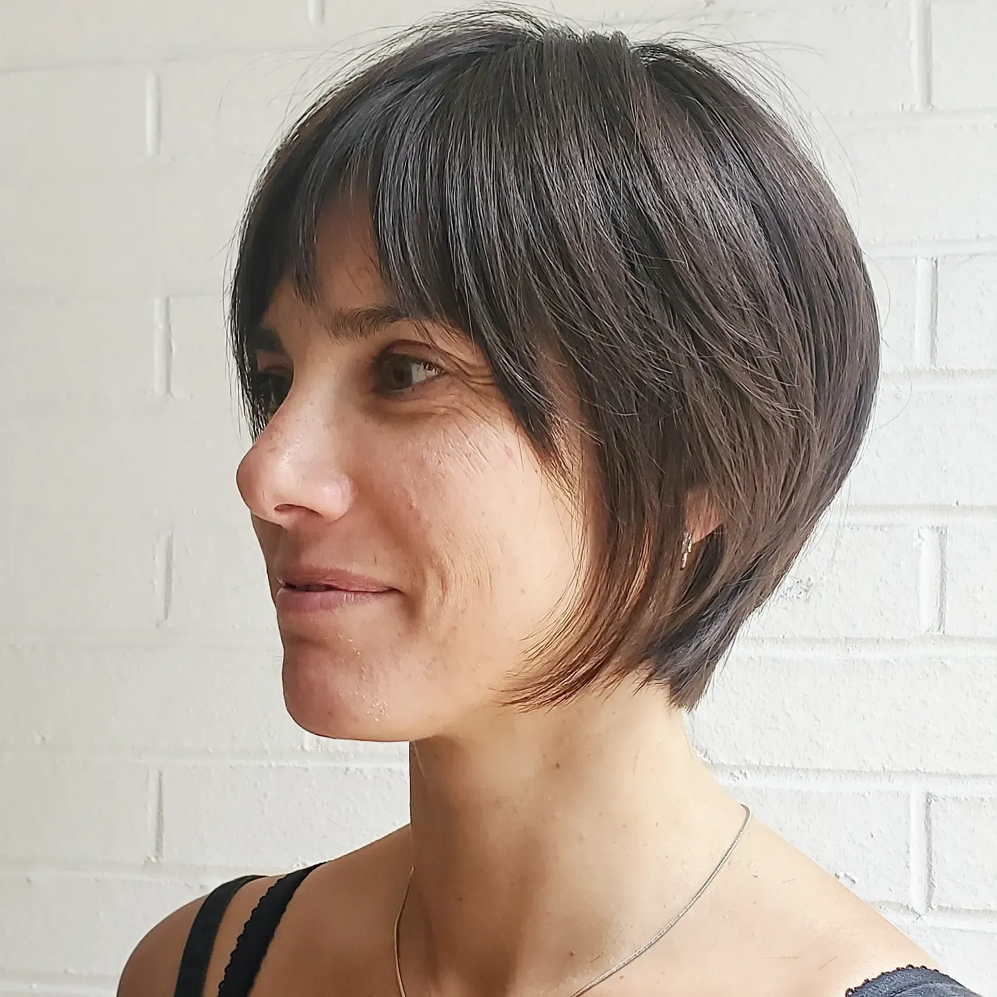 Tapered dark pixie bob with a long side fringe and soft nape