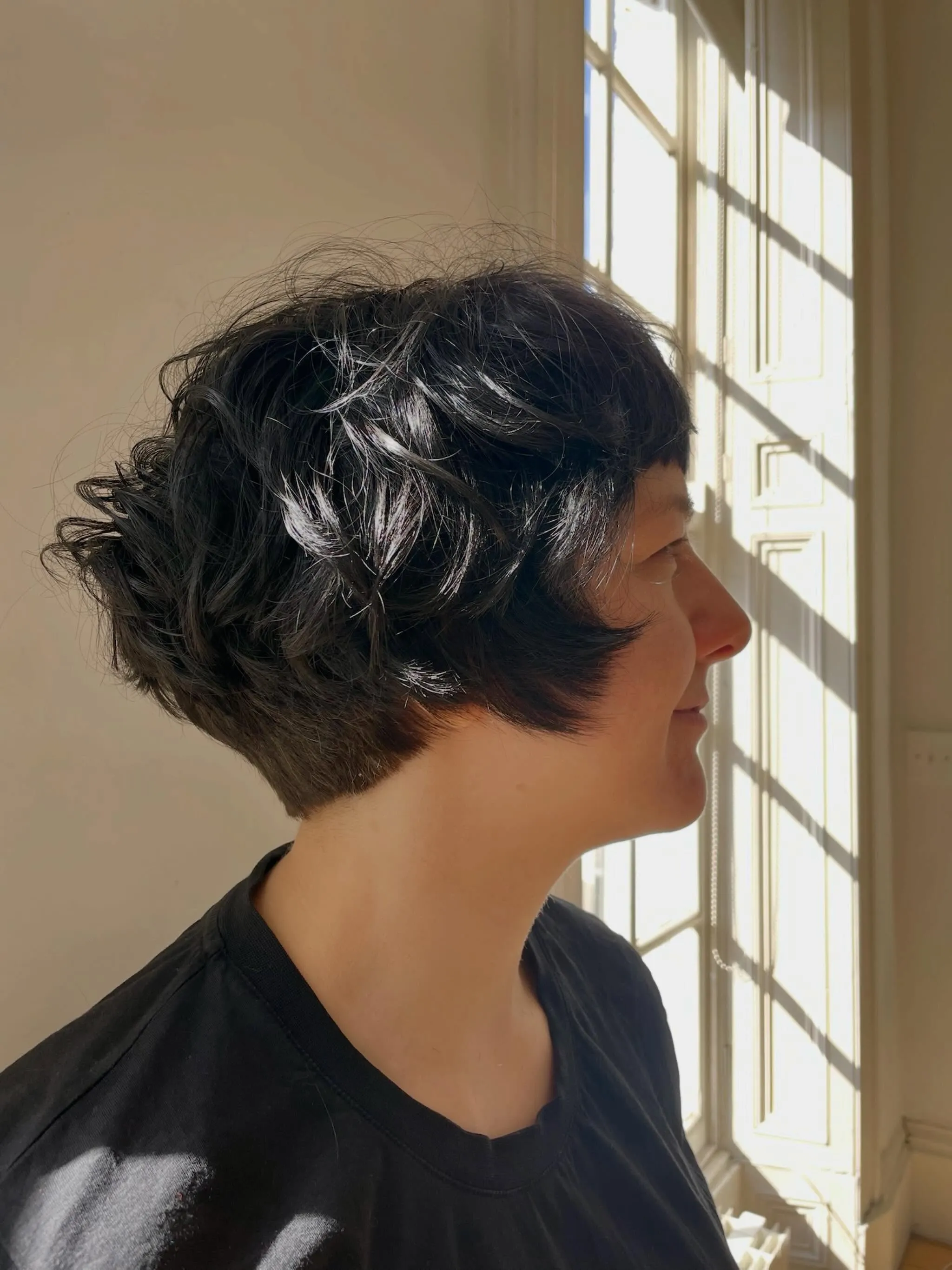 Rounded curly short crop with a soft fringe and tapered nape