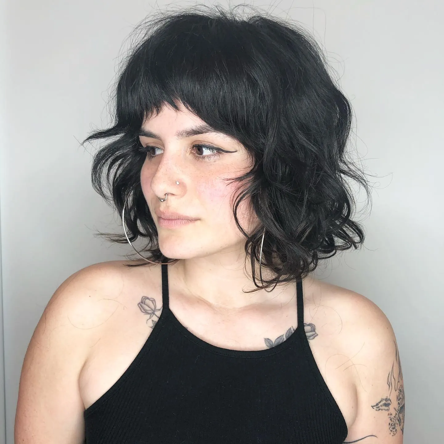 Tousled black curly bob with broken mini fringe
