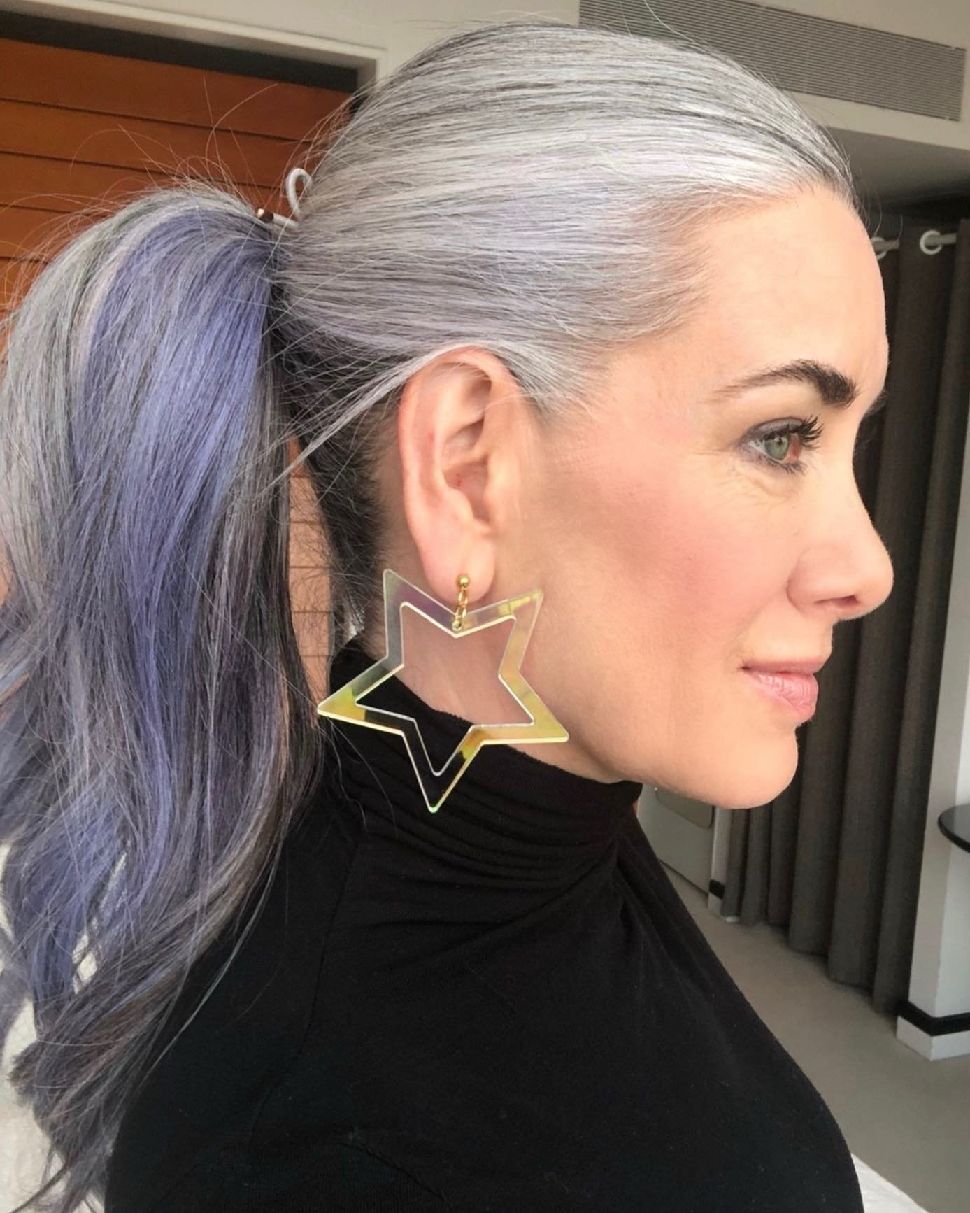 Sleek high ponytail with silver roots and long wavy lengths