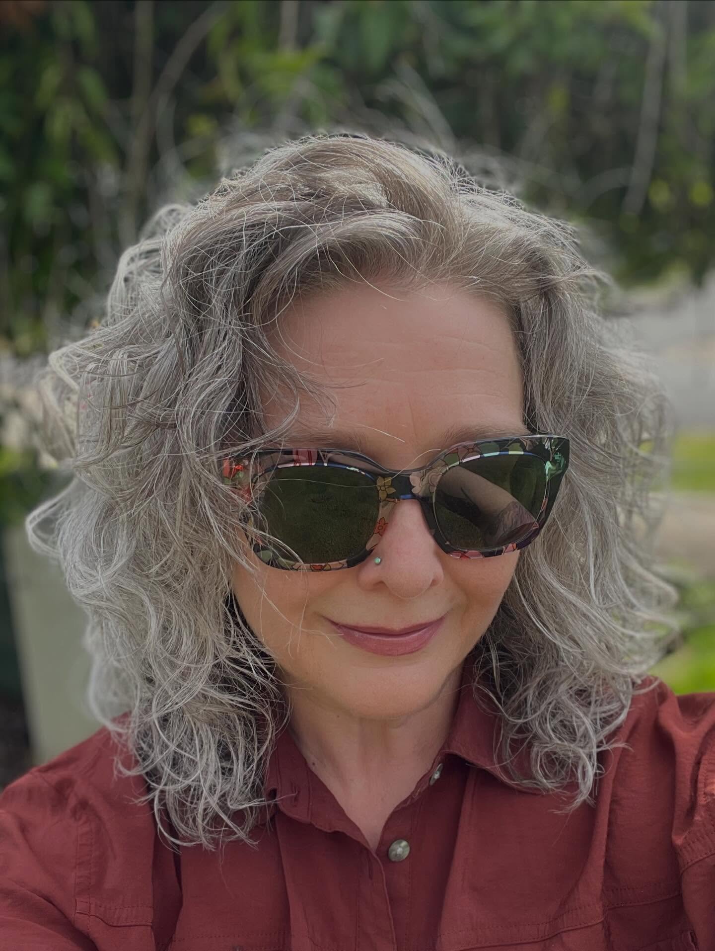 Shoulder-length gray curls with swept-back crown volume