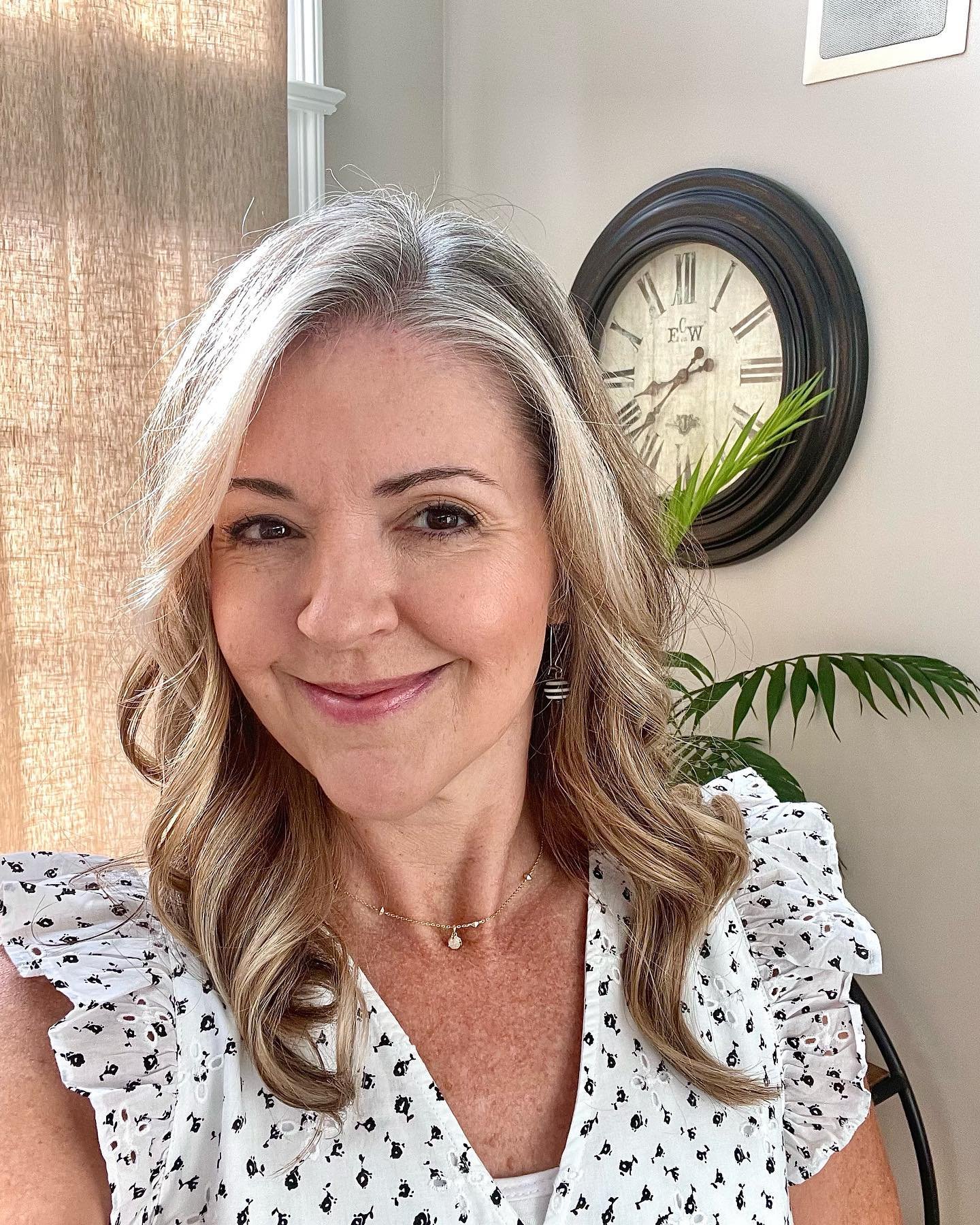 Long gray hair with soft curls and a side part