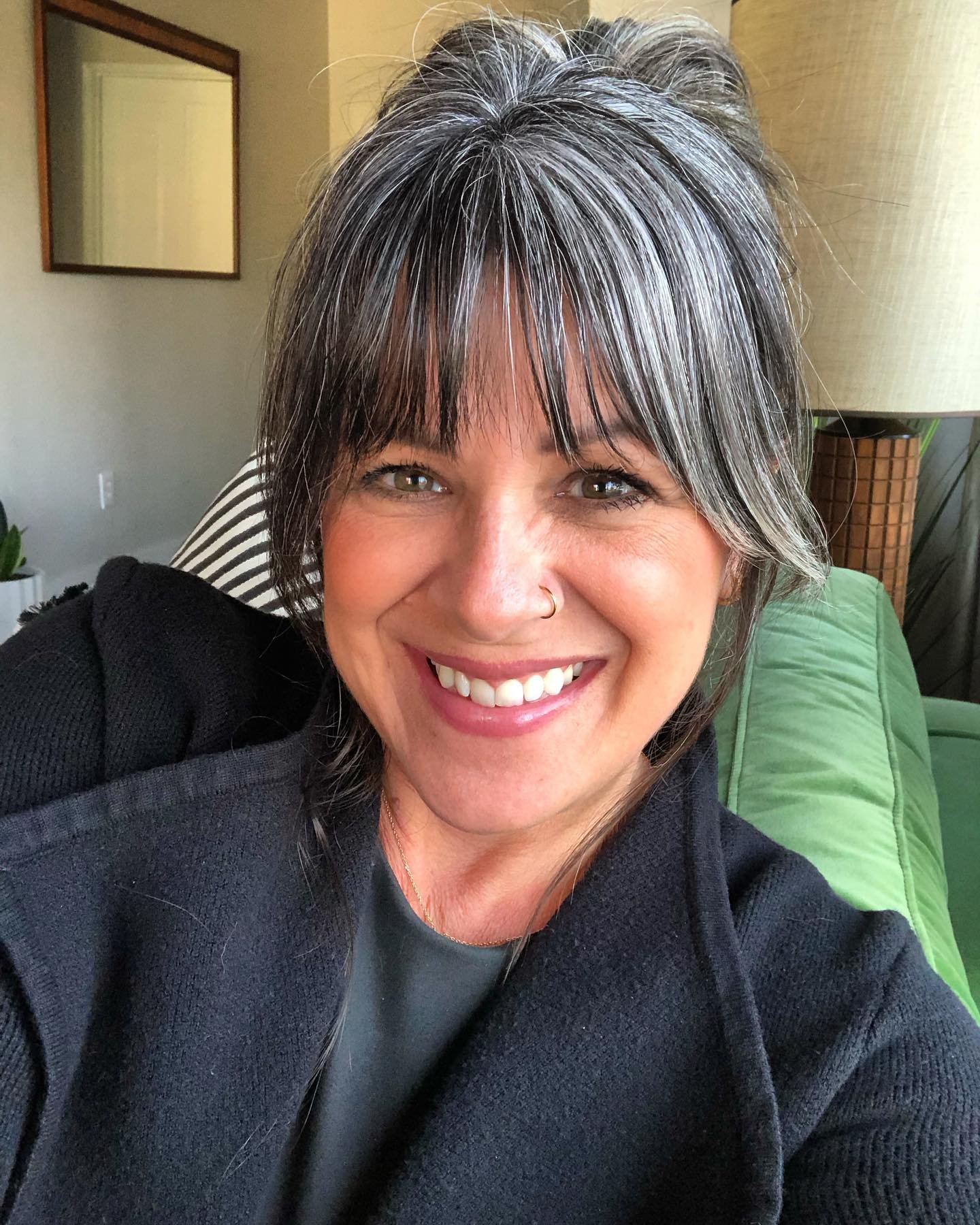 Textured gray updo with a full fringe and loose side pieces