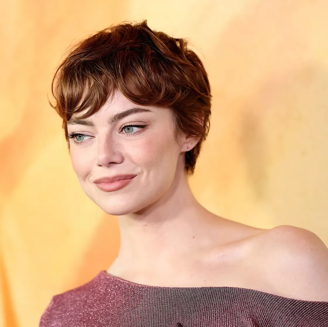 Short auburn wavy pixie with a side fringe and tapered sides