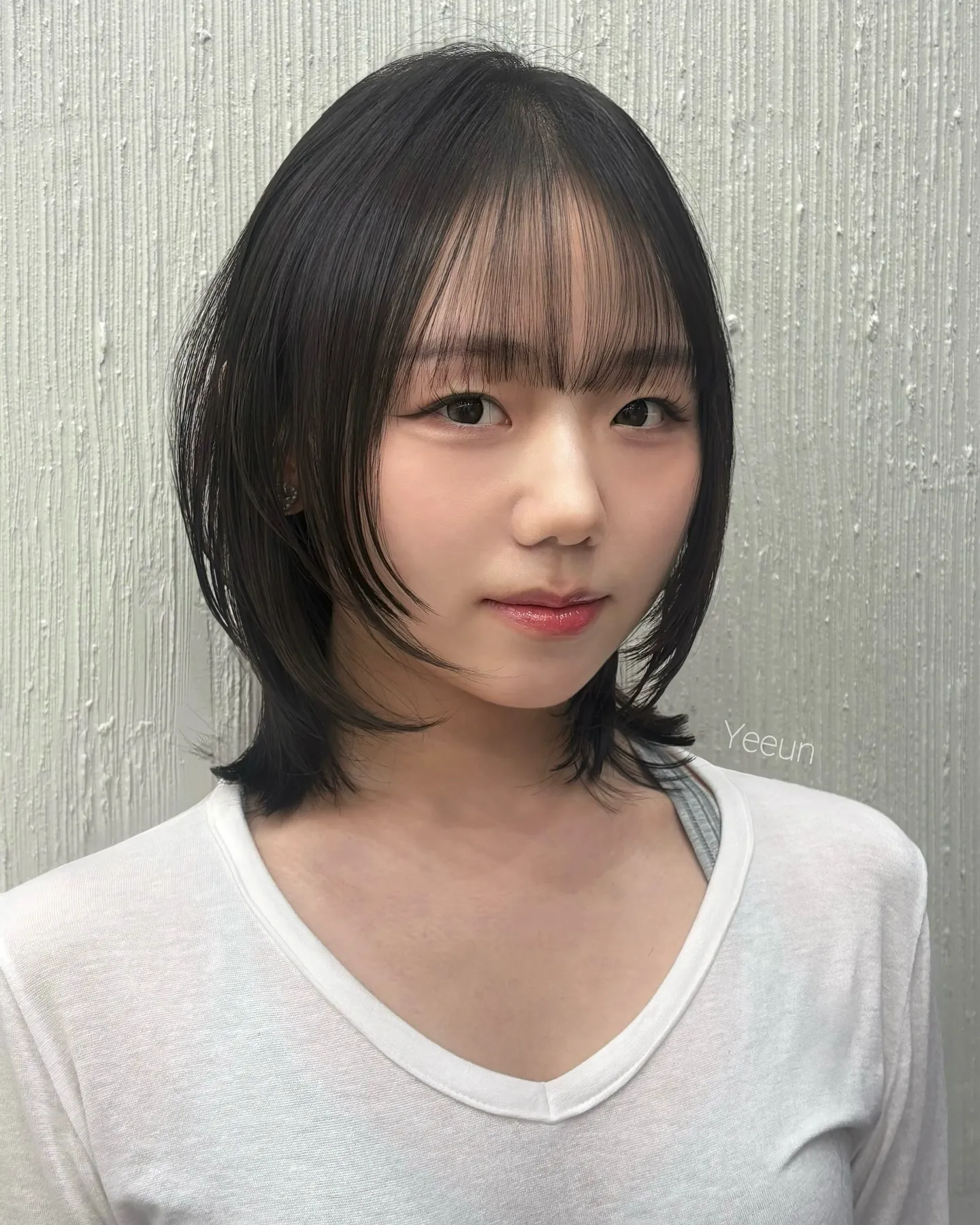 Layered dark shoulder-length bob with wispy full bangs