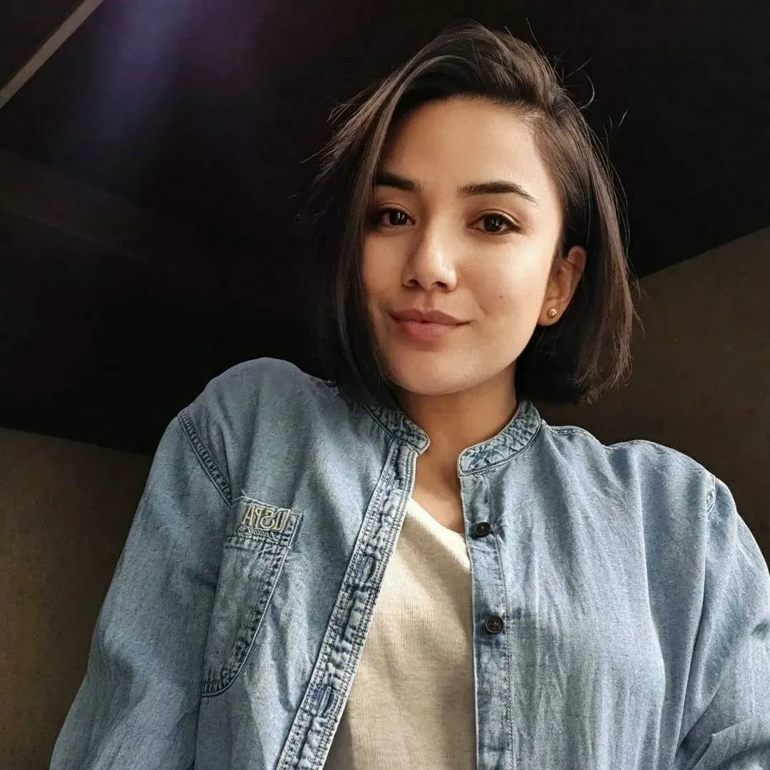 Asymmetrical dark bob with a side part and one side tucked behind the ear