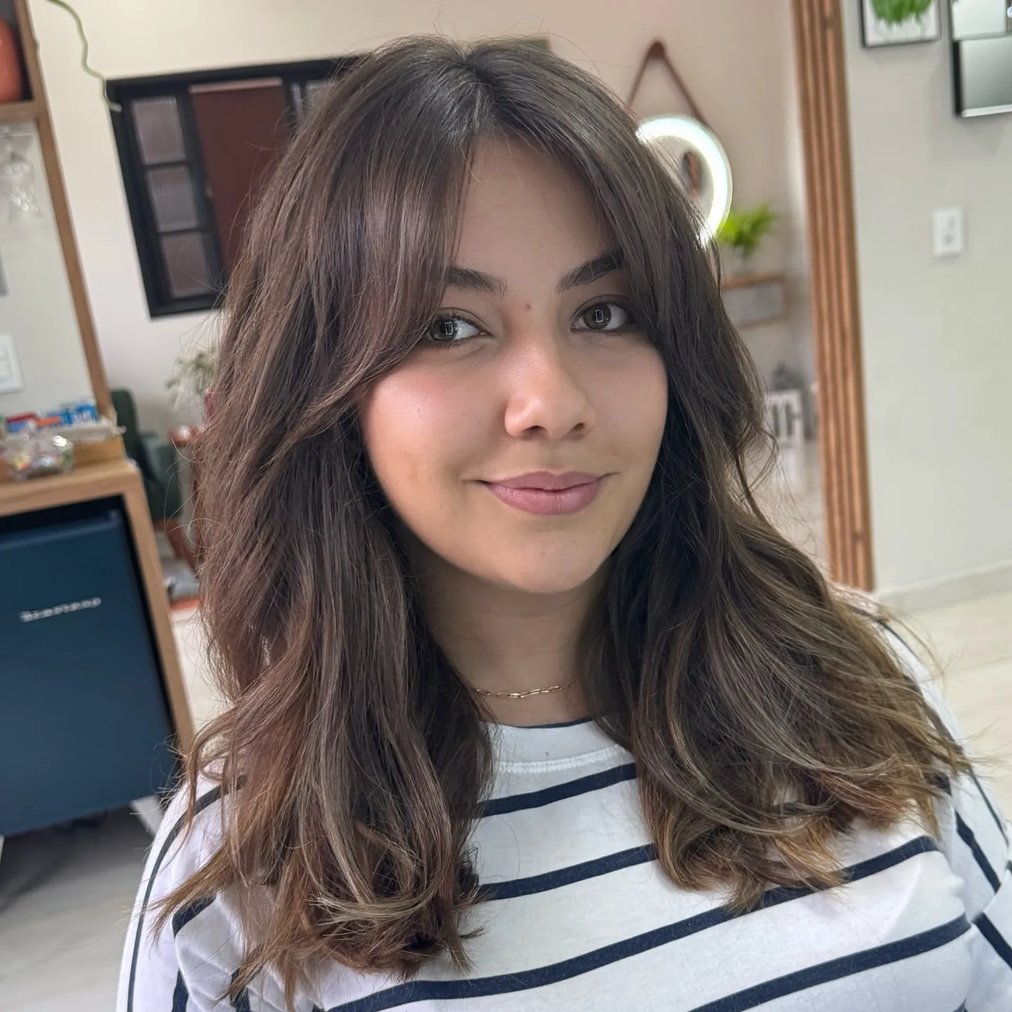 Long dark layered waves with curtain bangs and face-framing pieces
