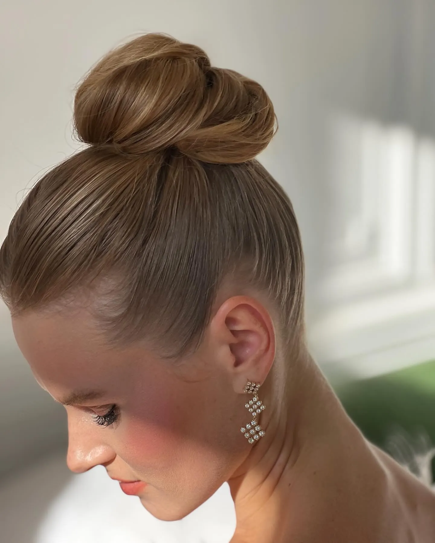 Polished blonde top knot with a smooth crown and wrapped base