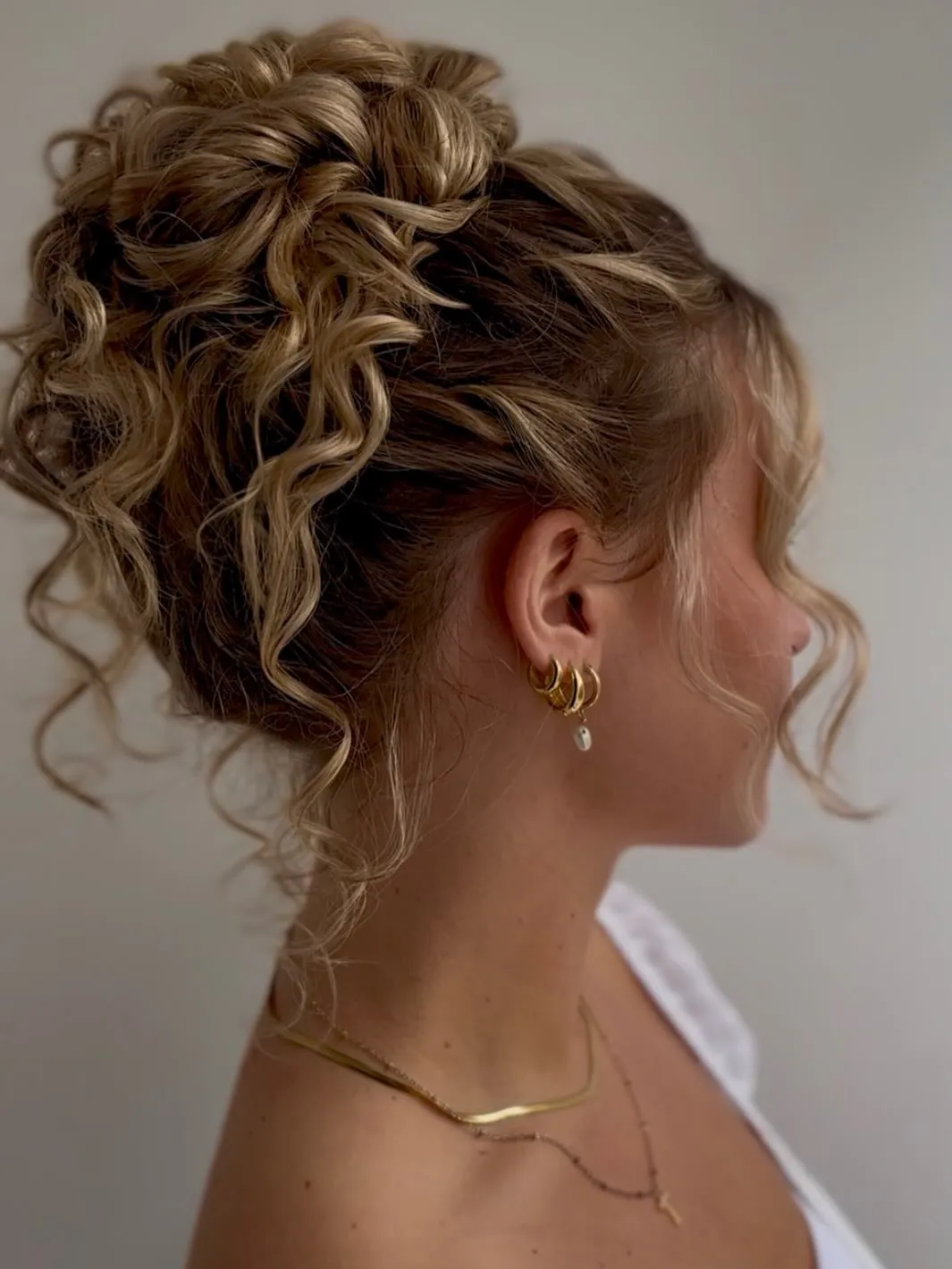 Curly blonde high updo with natural volume and loose ringlets