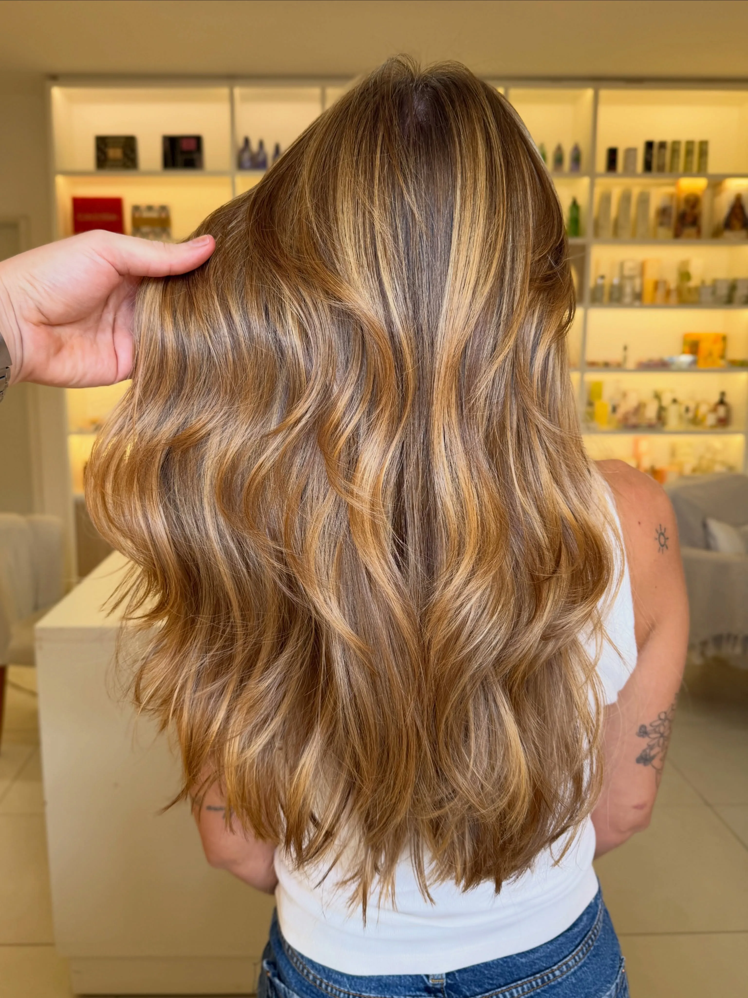 Long glossy waves with warm blonde highlights