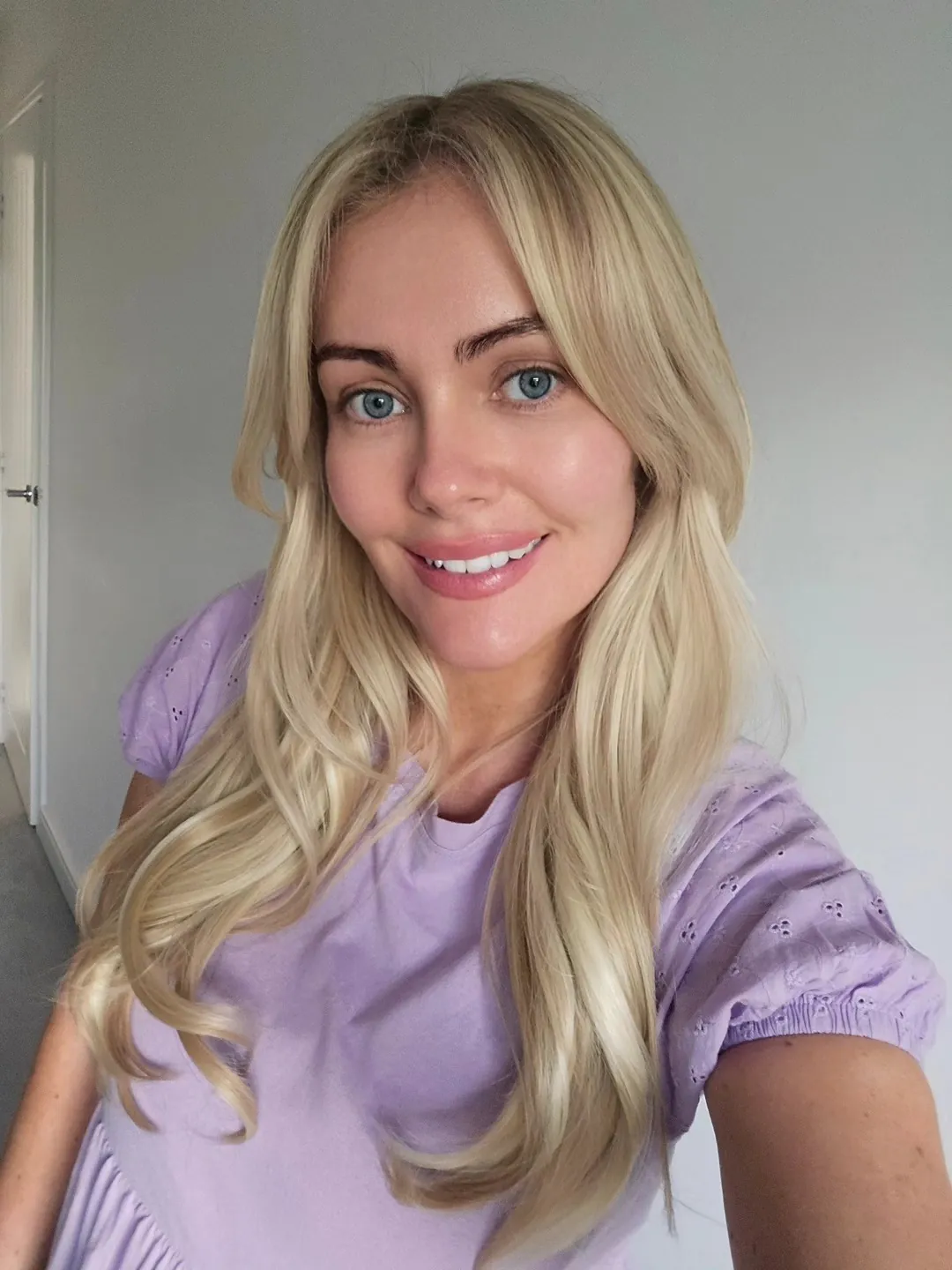 Long blonde hair with soft curls and face-framing layers