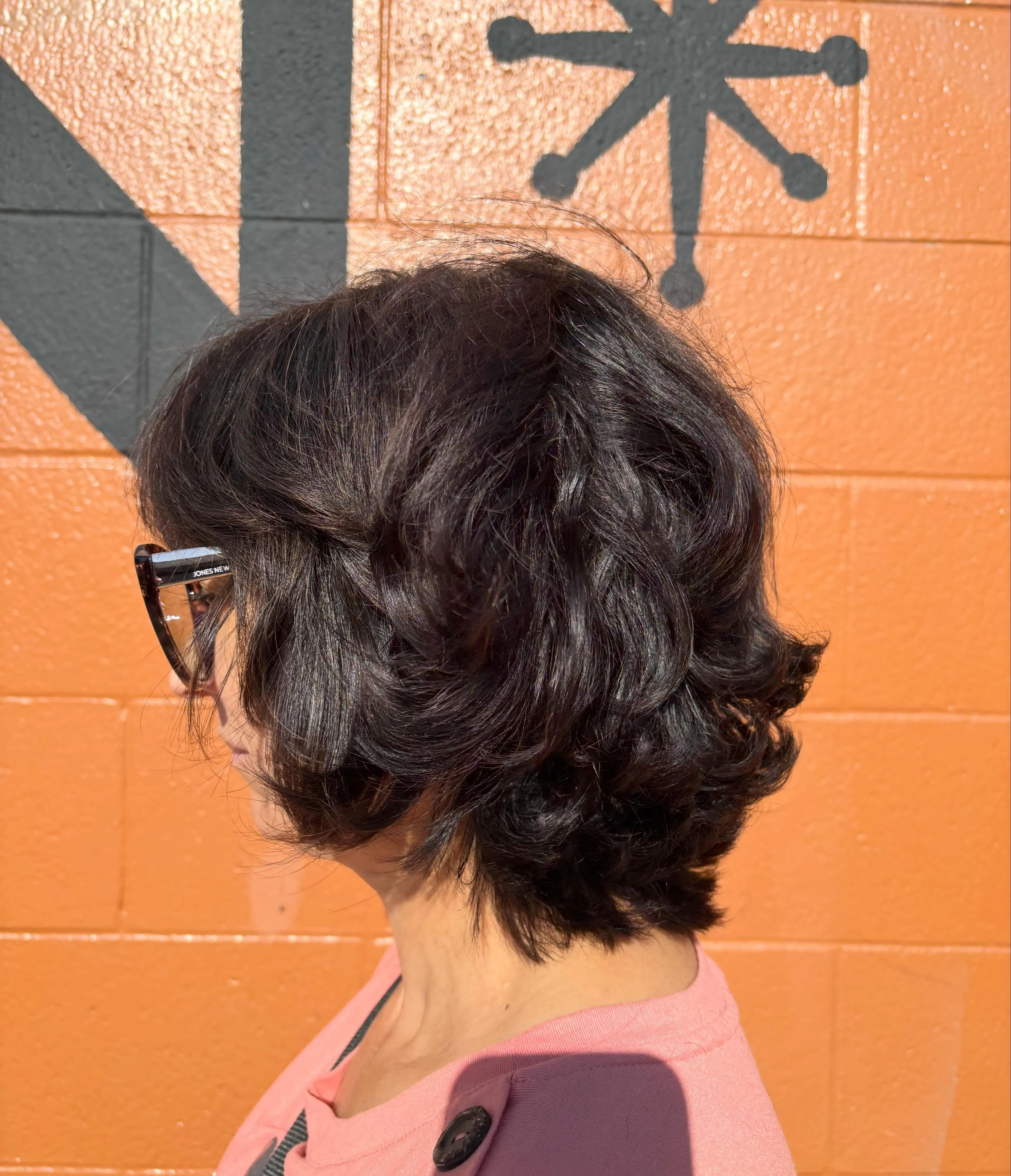 Voluminous wavy layered bob with swept-back bangs