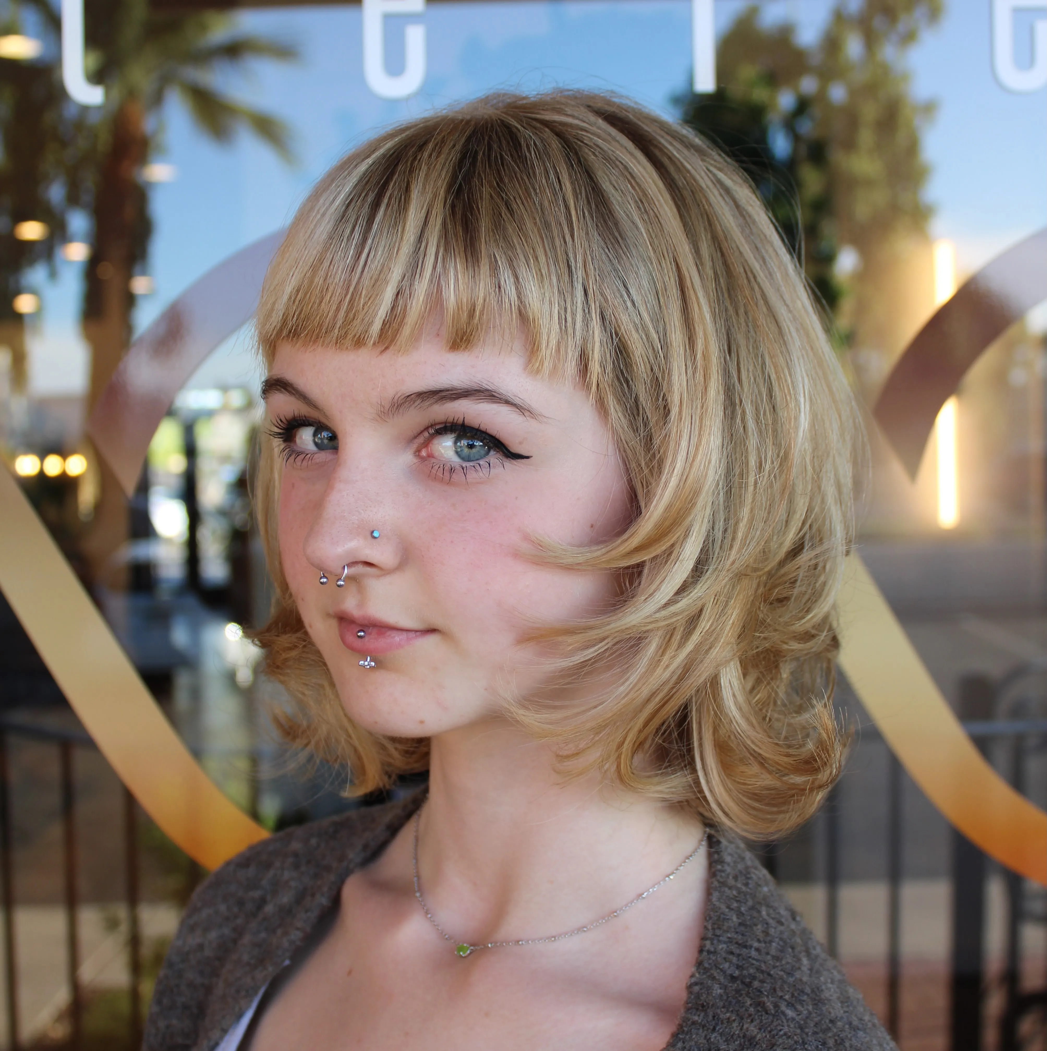 Layered blonde bob with micro fringe and curled under ends