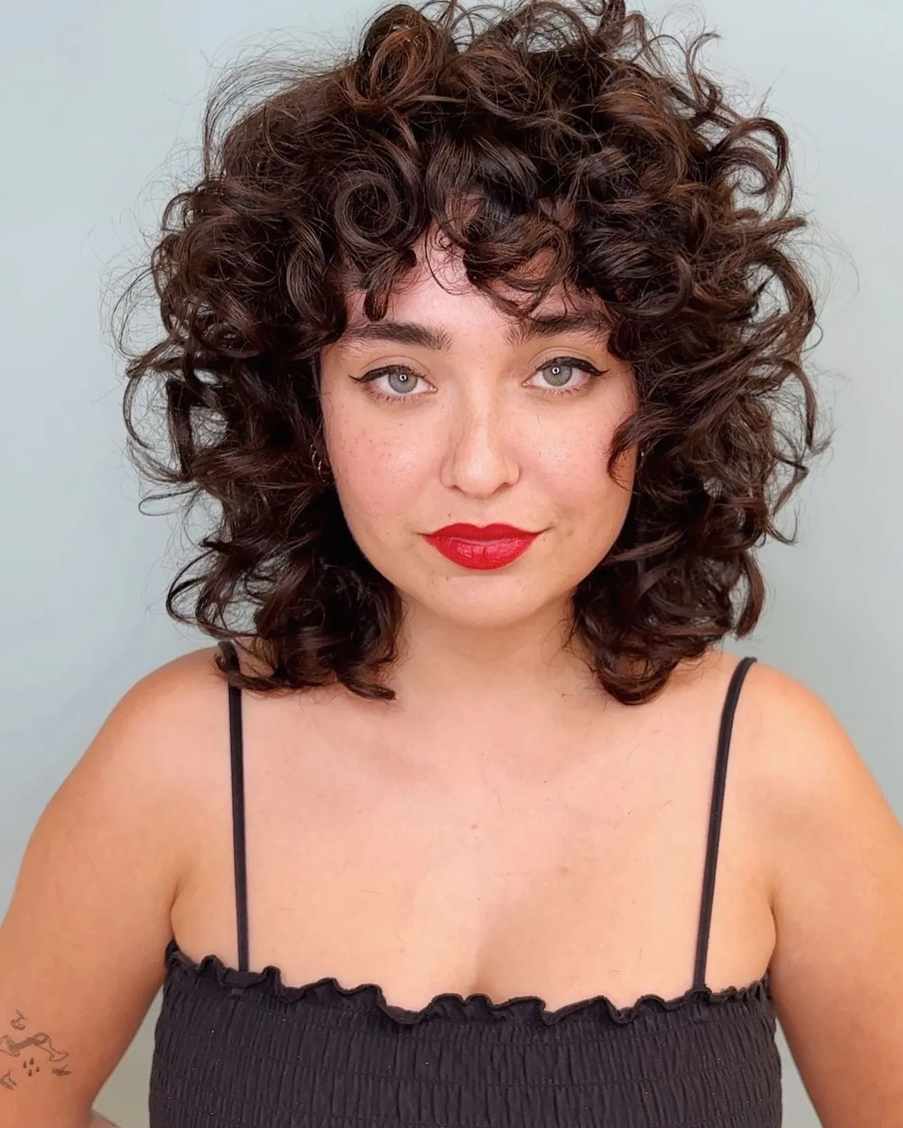 Curly shag bob with rounded layers and fringe