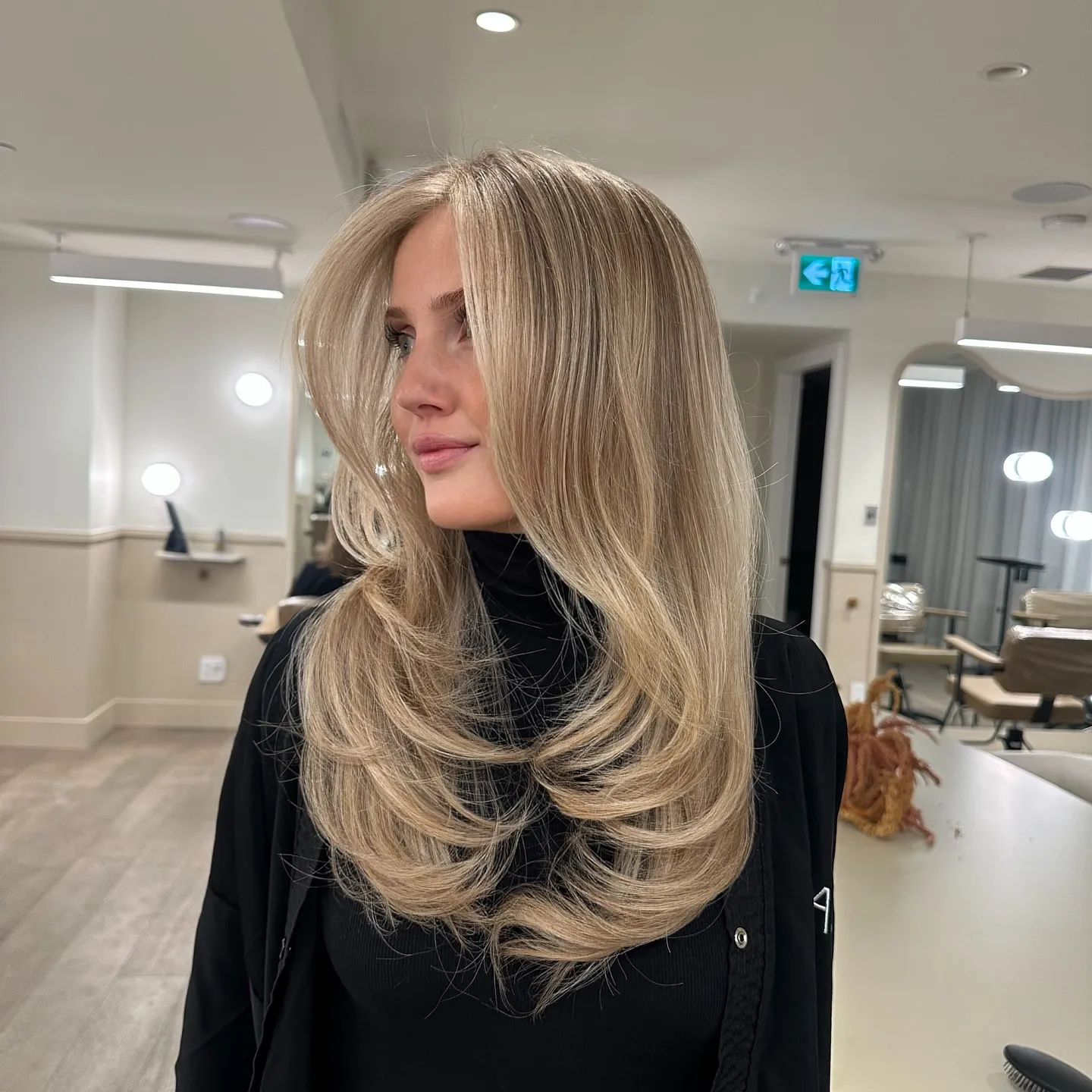 Layered light blonde hair with full curved ends
