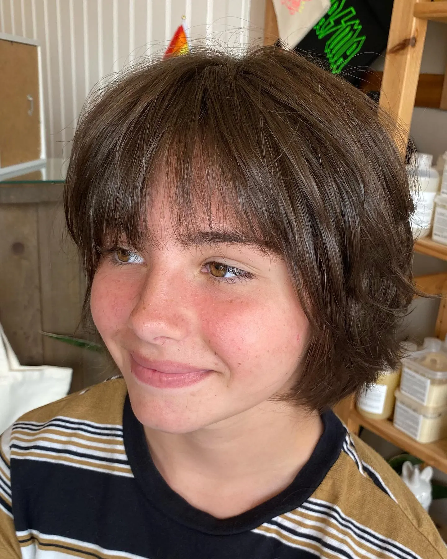 Rounded brunette bixie with full soft fringe and tapered nape