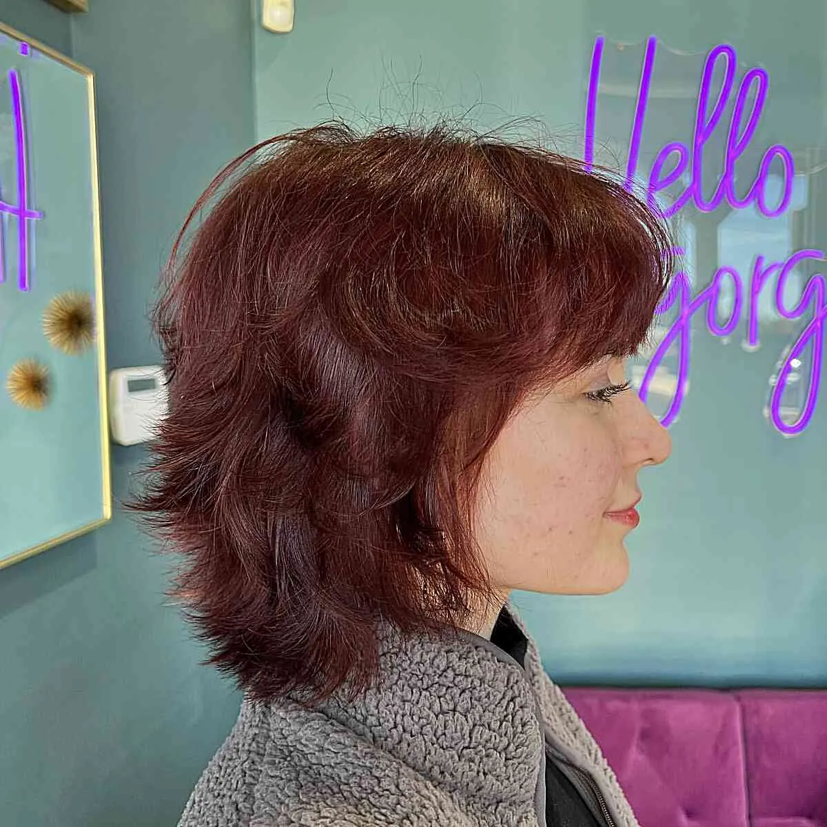 Feathered red bixie with side-swept fringe and longer nape