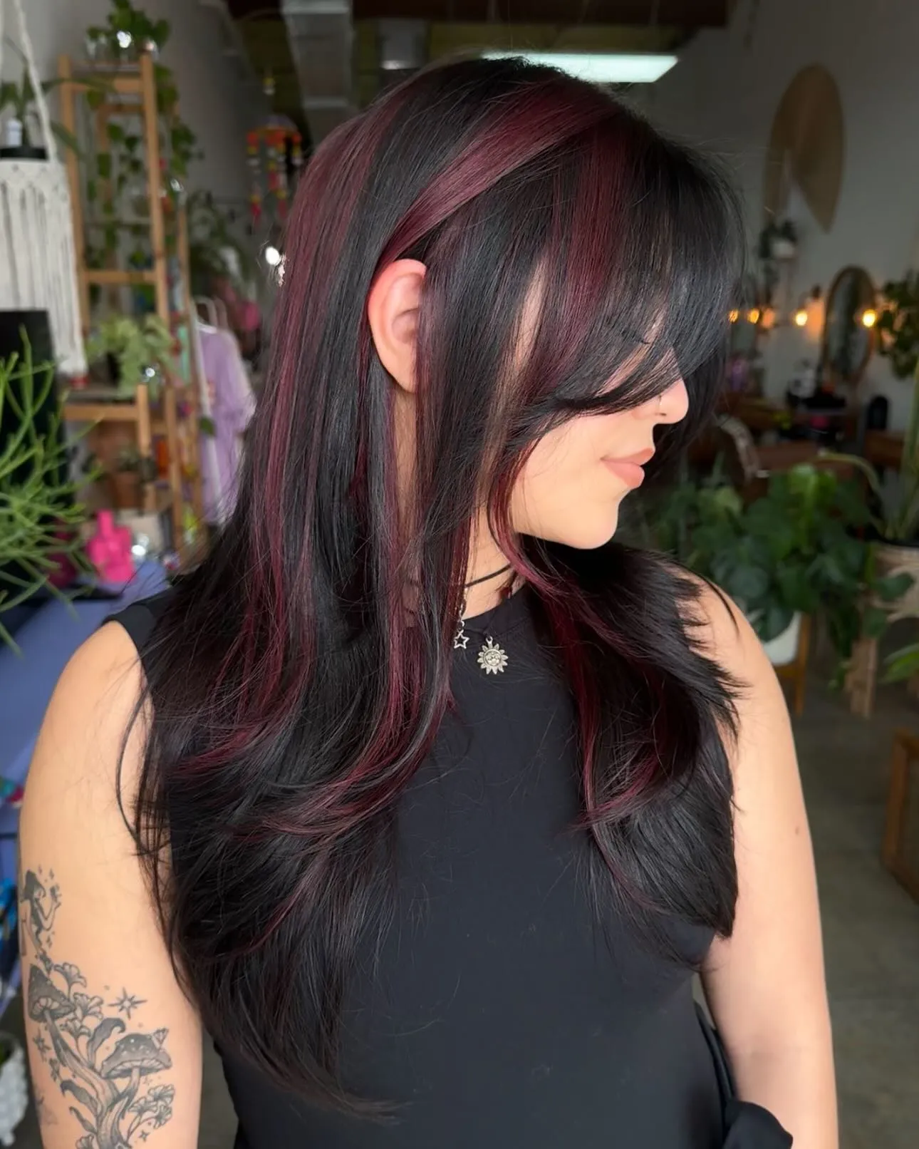 Long black hair with burgundy face framing and layers