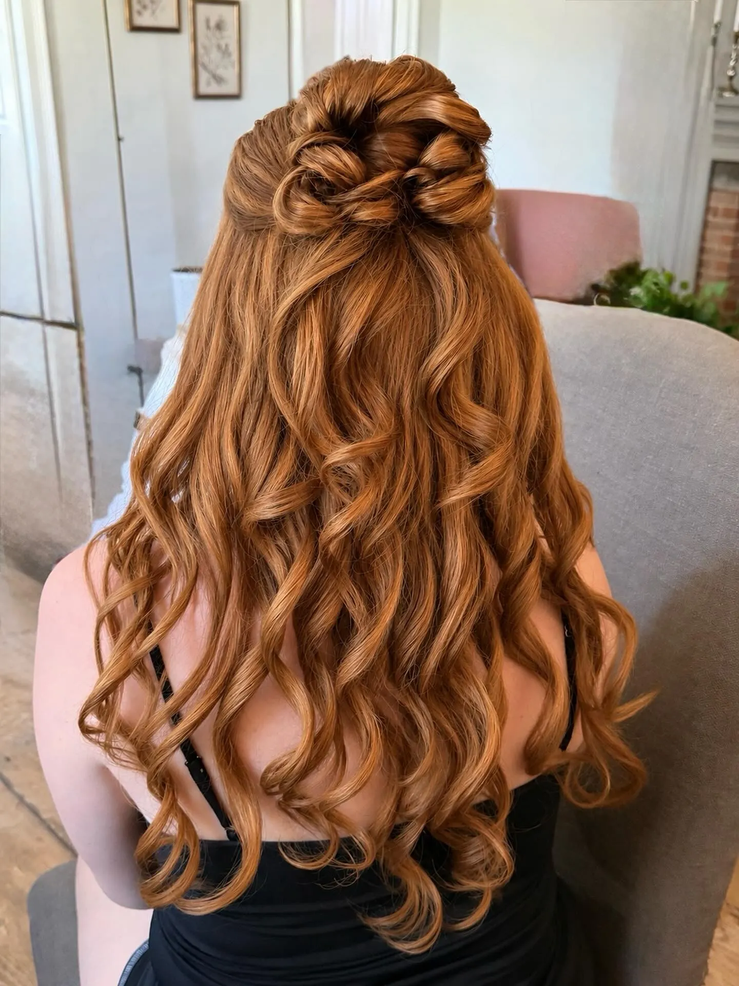 Half-up wedding hairstyle with a braided knot and long defined curls