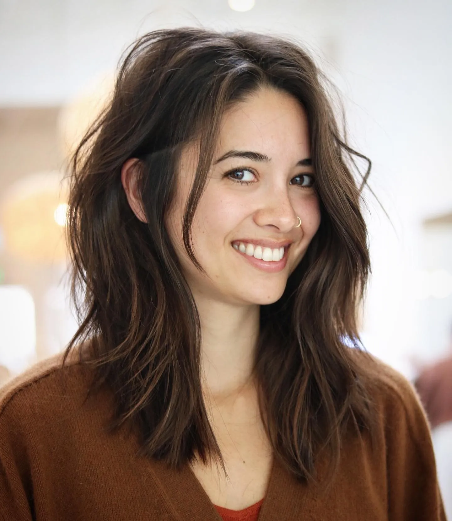 Tousled dark shoulder-length hair with a side part