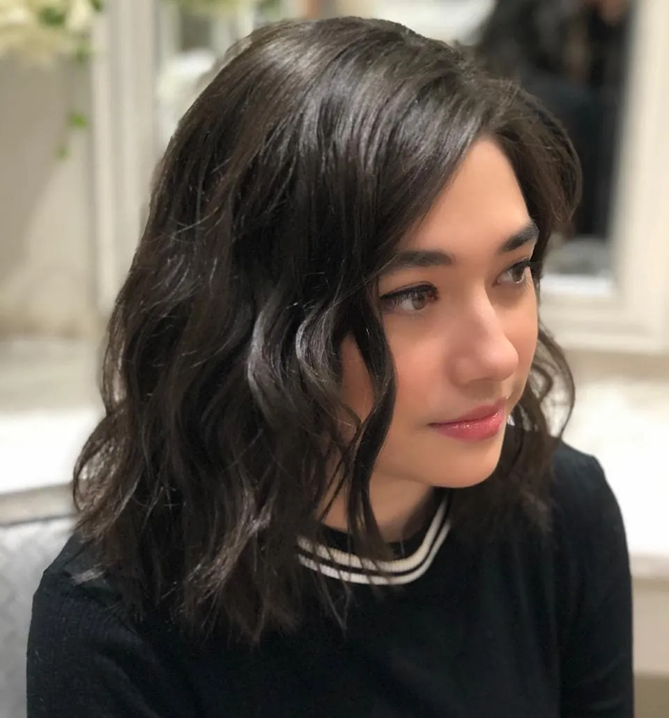 Dark side-parted shoulder-length hair with loose waves