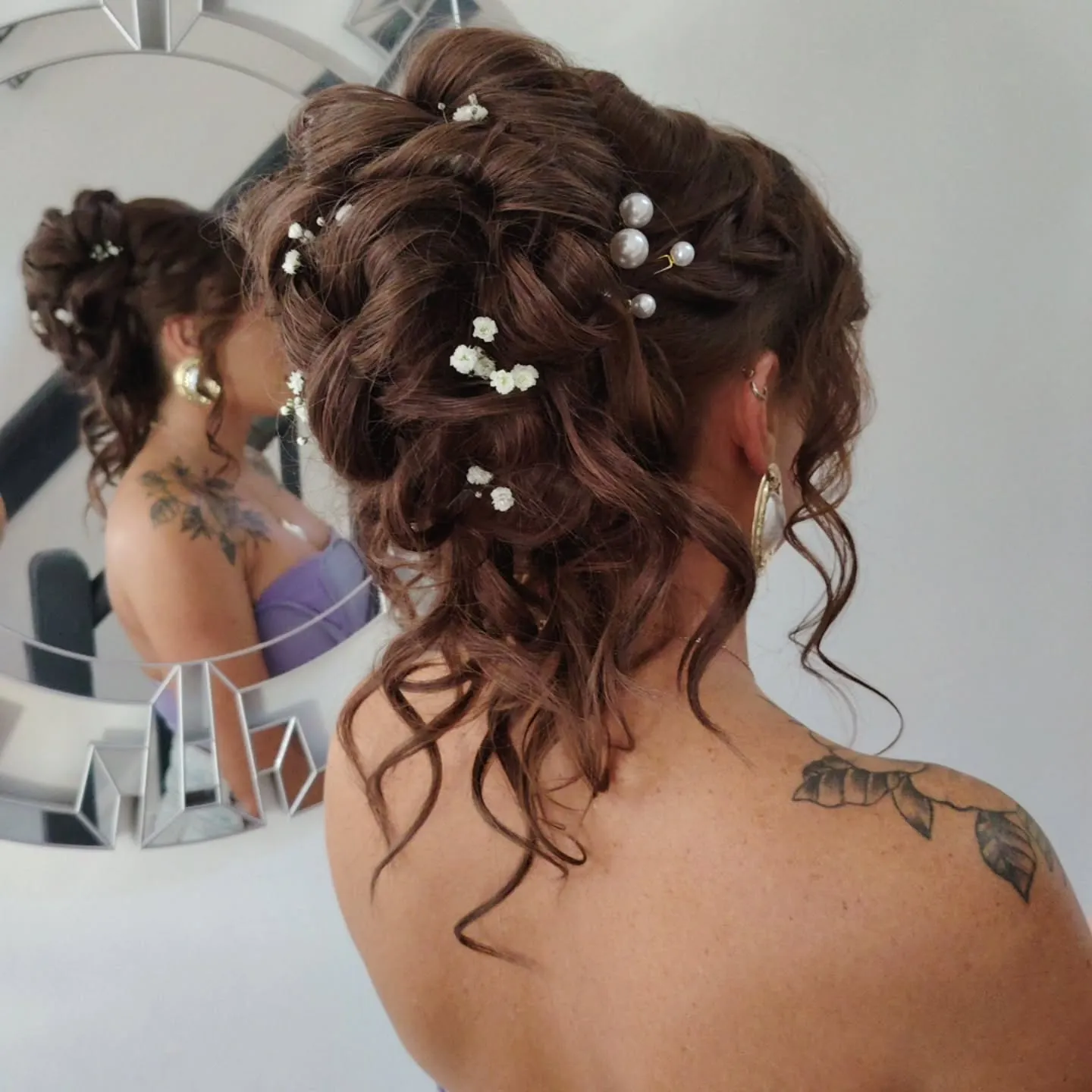 High curly brown bun with pearl and small white flower pins