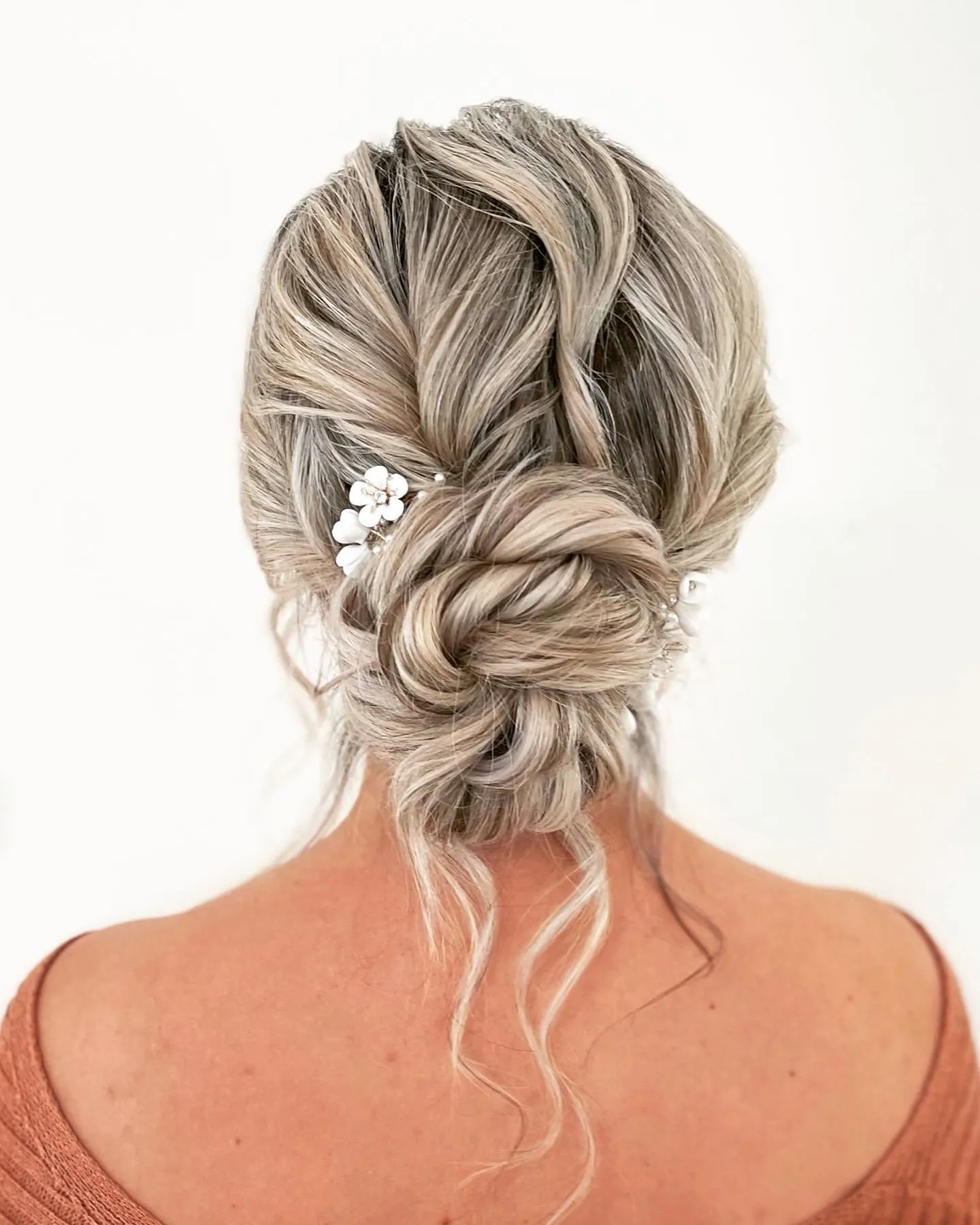 Braided low blonde bun with tiny white flower pins
