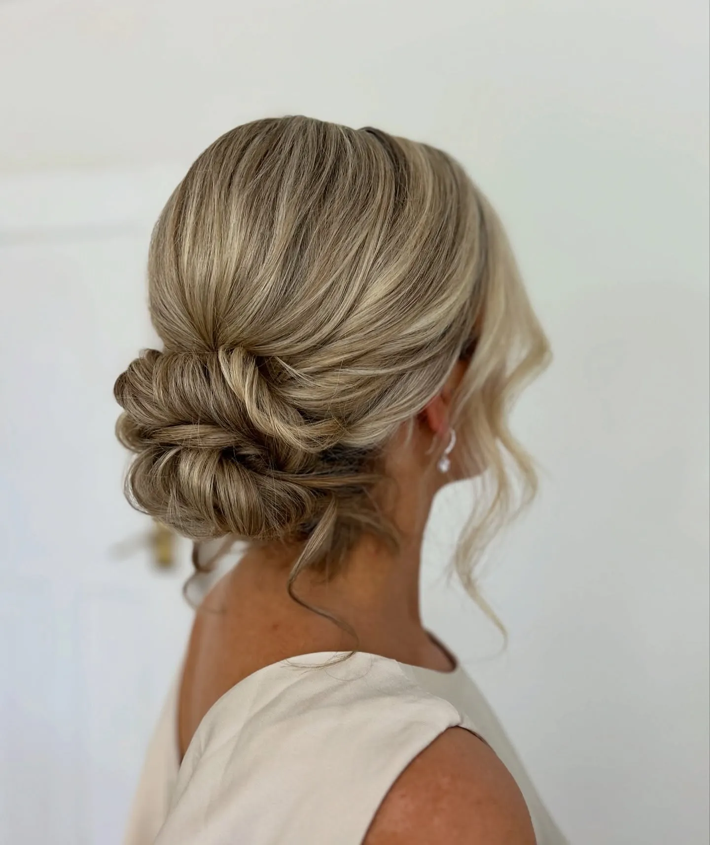 Wrapped low blonde bun with smooth overlapping sections