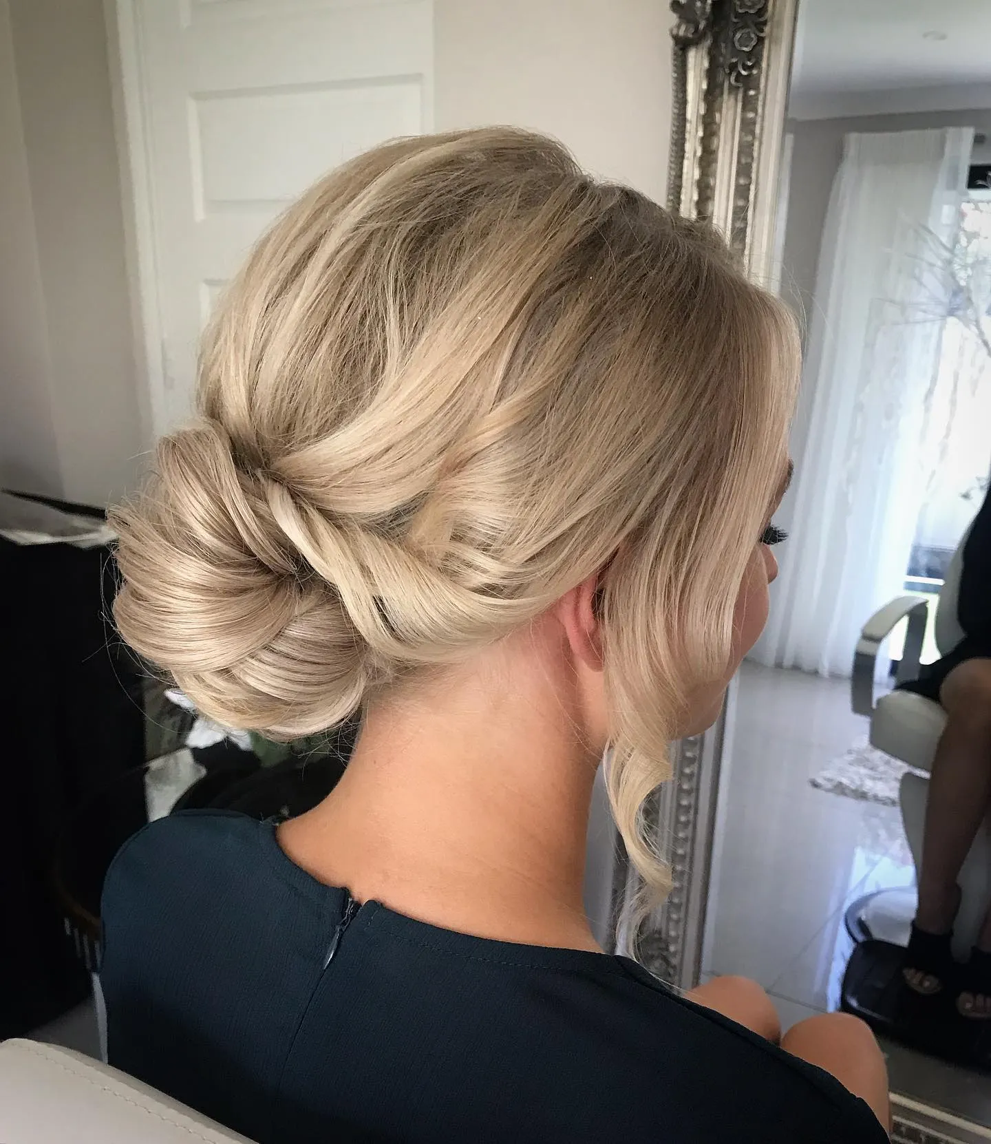 Braided low blonde bun with softly swept sides