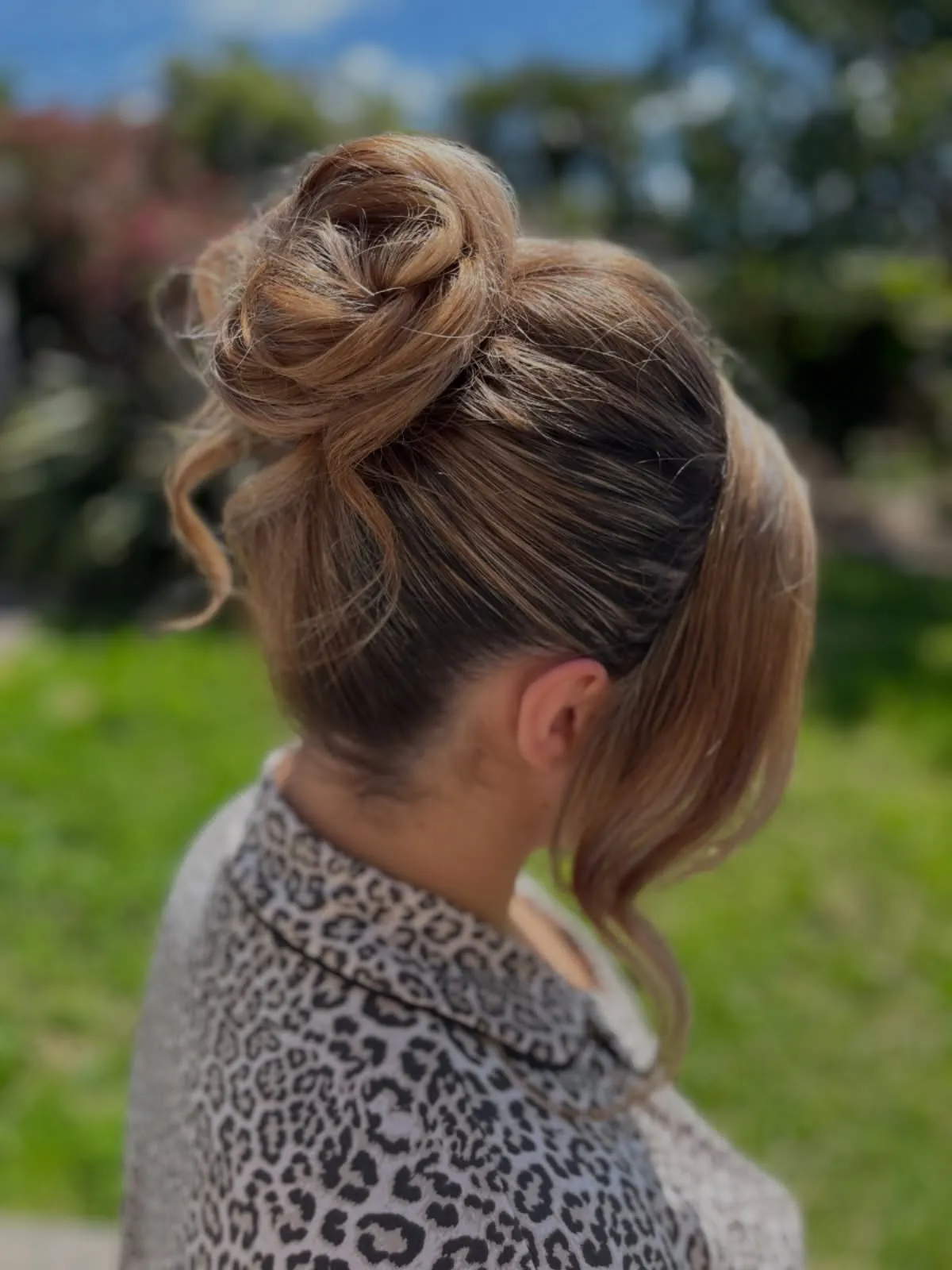High messy bun with side-swept fringe and loose curl