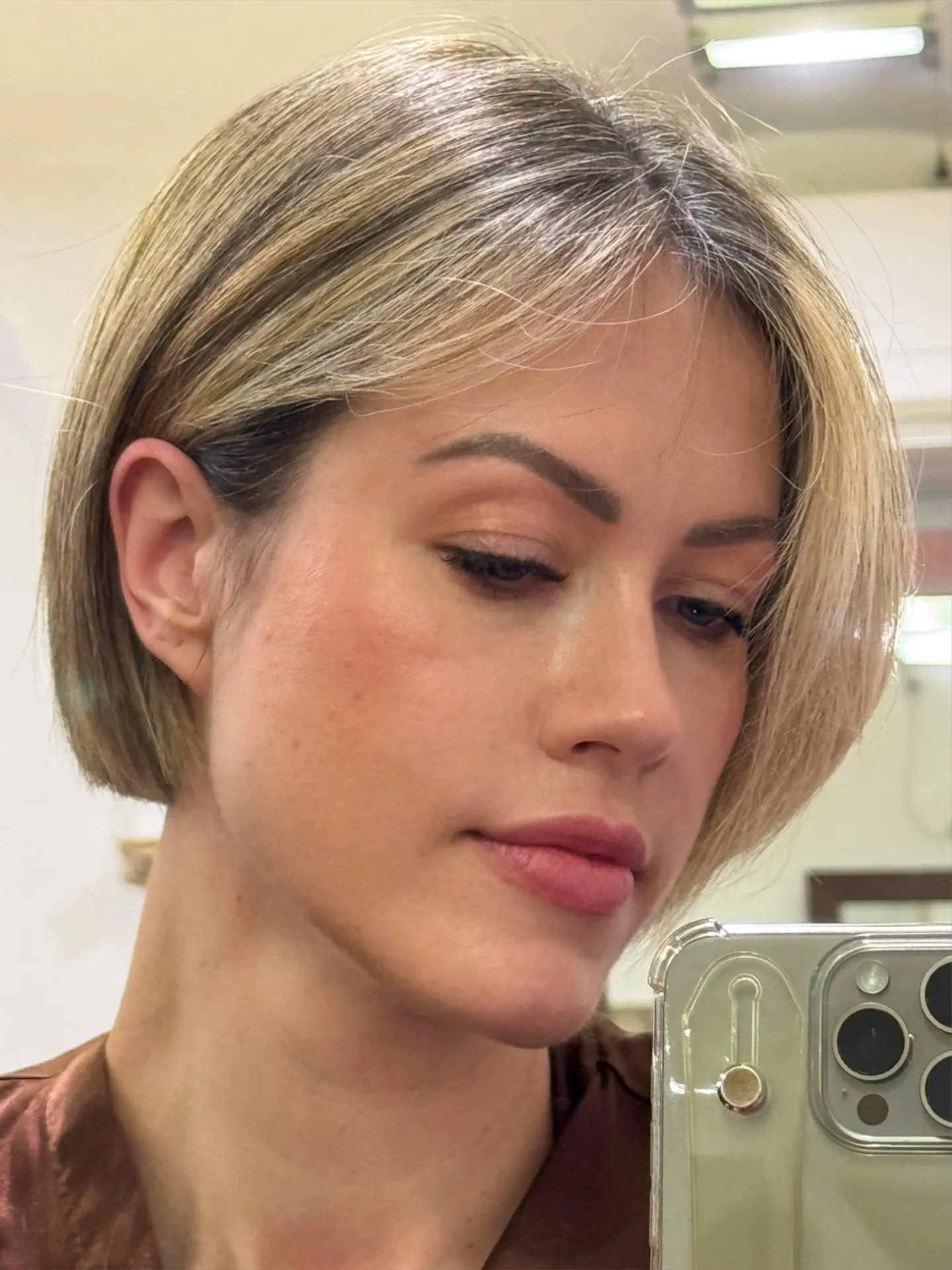Straight blonde micro bob with a centre part and tucked sides