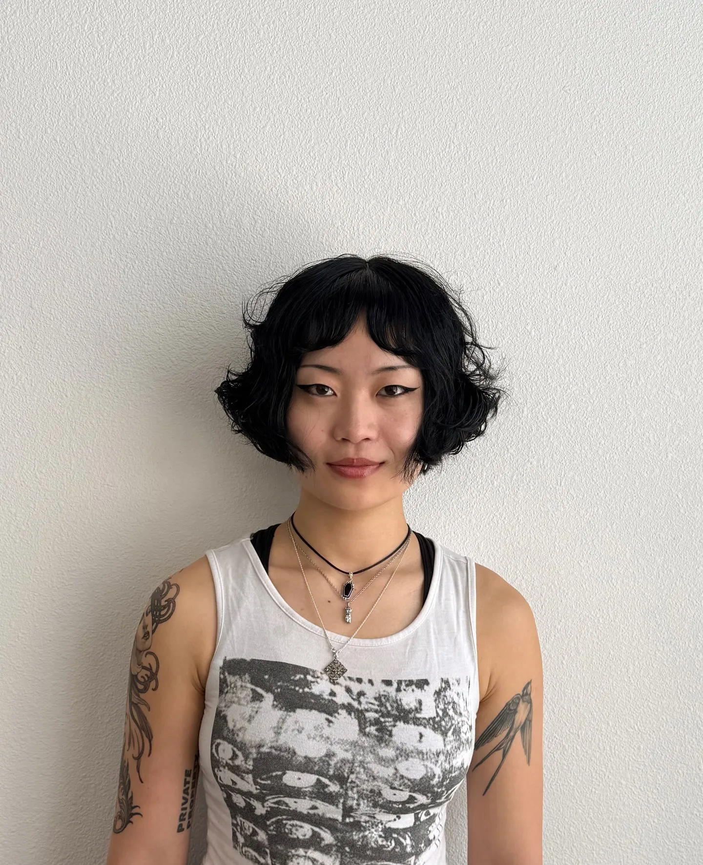 Black wavy micro bob with rounded volume and softly curled ends