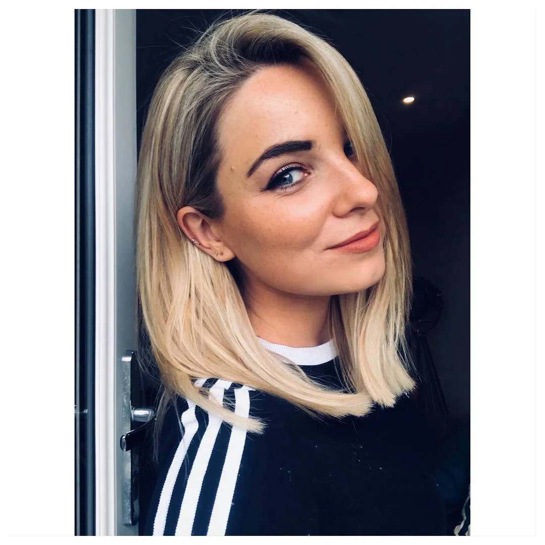 Sleek blonde midi bob with a deep side part