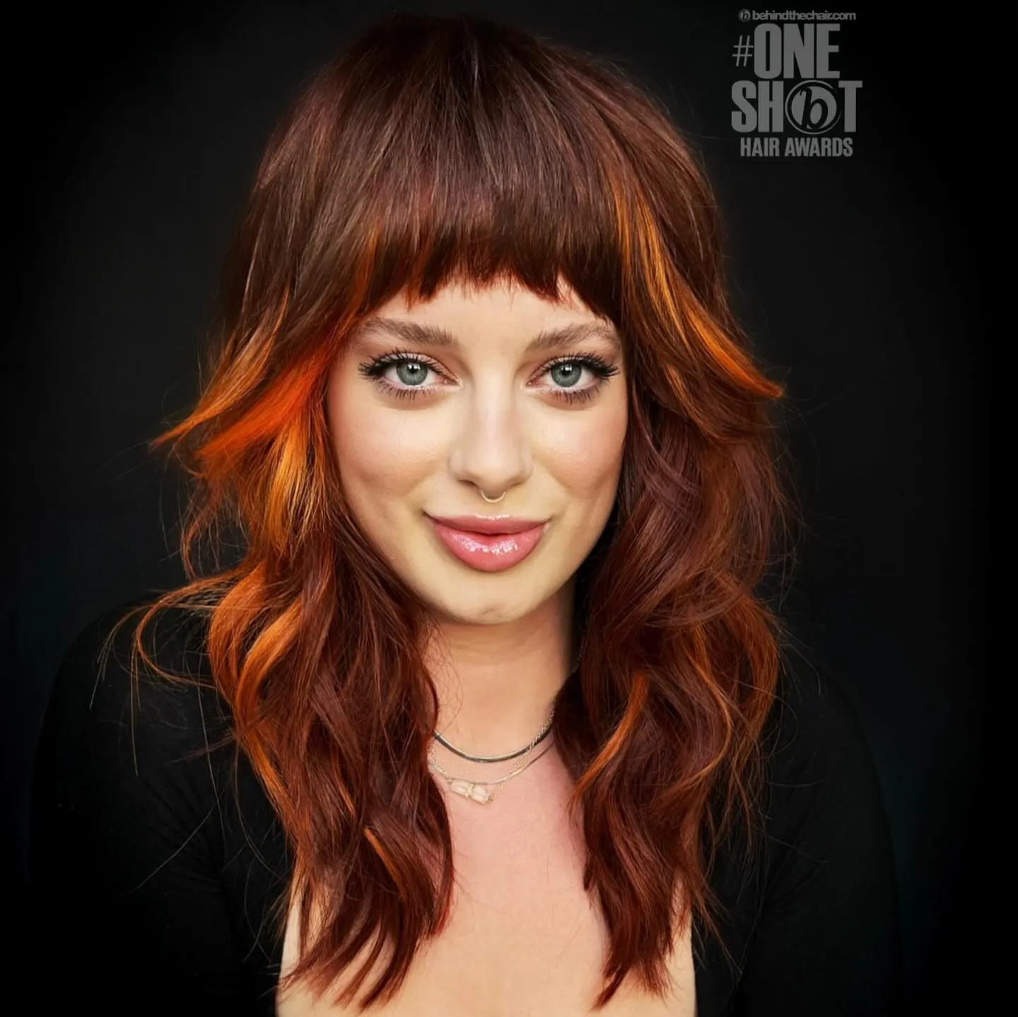 Long red shag with blunt fringe and vivid orange face-framing pieces