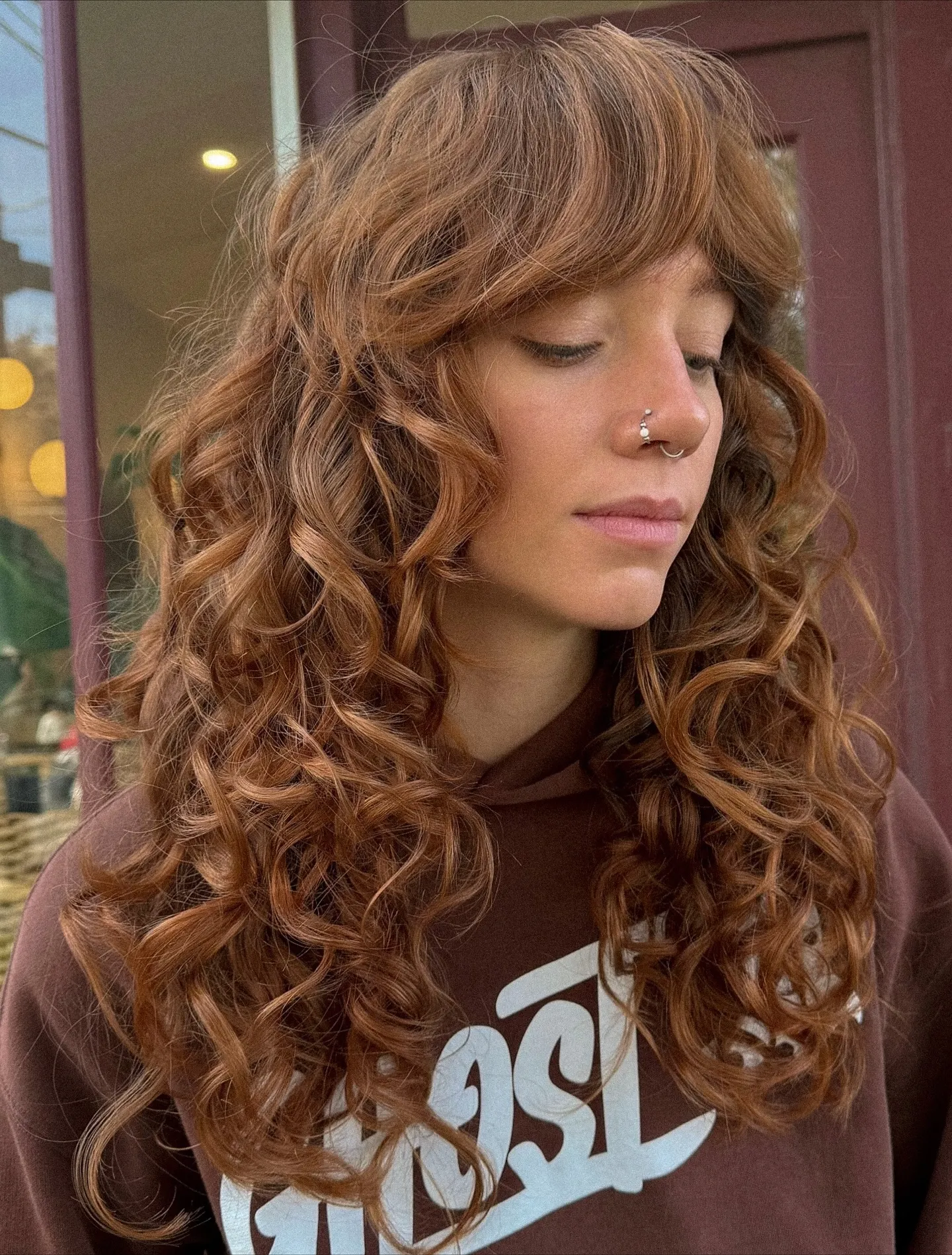 Long curly shag with full soft fringe and warm brown-copper tone