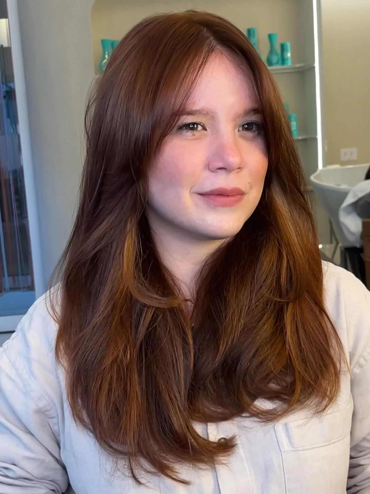 Long brunette layers with subtle copper warmth and center part