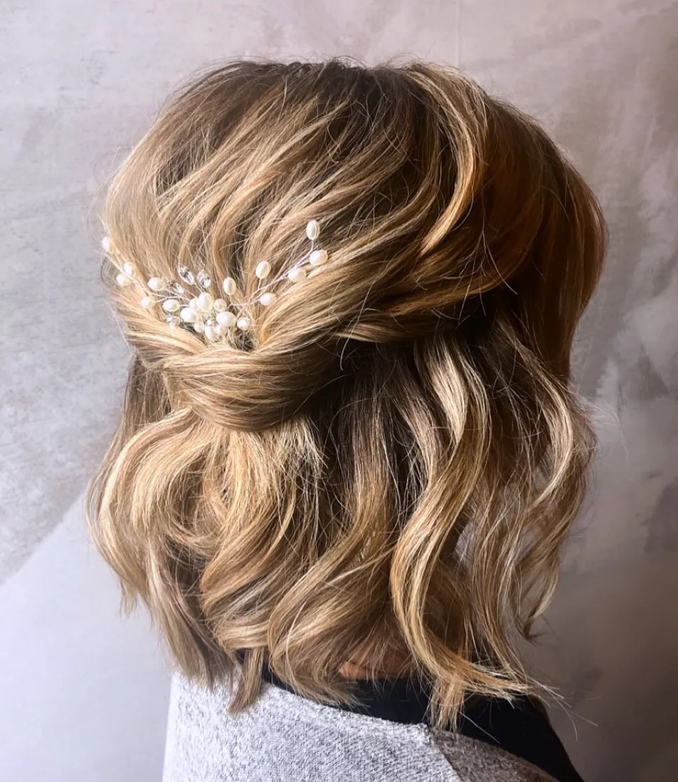 Shoulder-length half-up waves with a pearl branch accessory