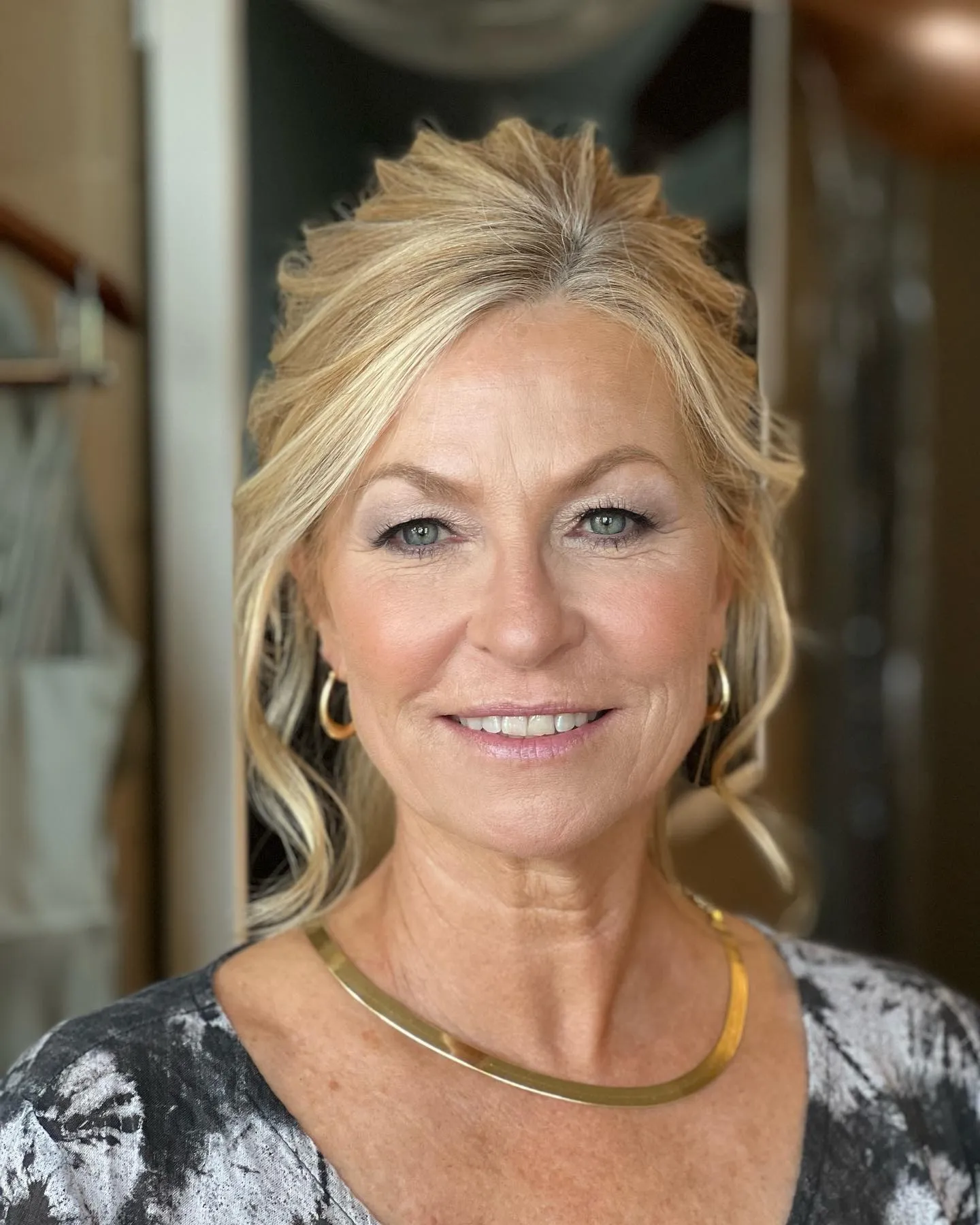 Blonde mother of the bride updo with loose face-framing curls